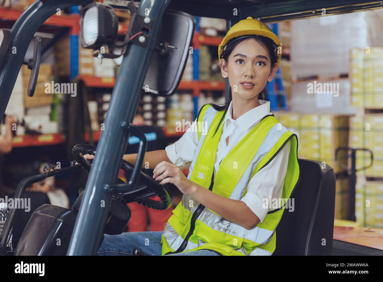 Lagerarbeiter, asiatische junge arbeitende Frauen arbeiten hart an der Fracht, die Gütercontainer mit Gabelstaplerwagen beladen Stockfoto