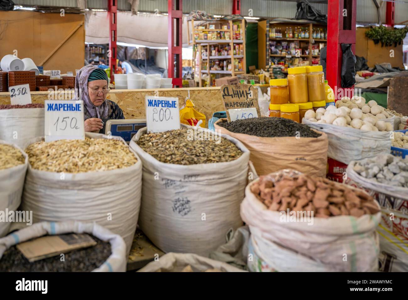 Traditionelle Frau, die Lebensmittel verkauft, Marktstand auf dem Osh Basar, Bischkek, Kirgisistan Stockfoto