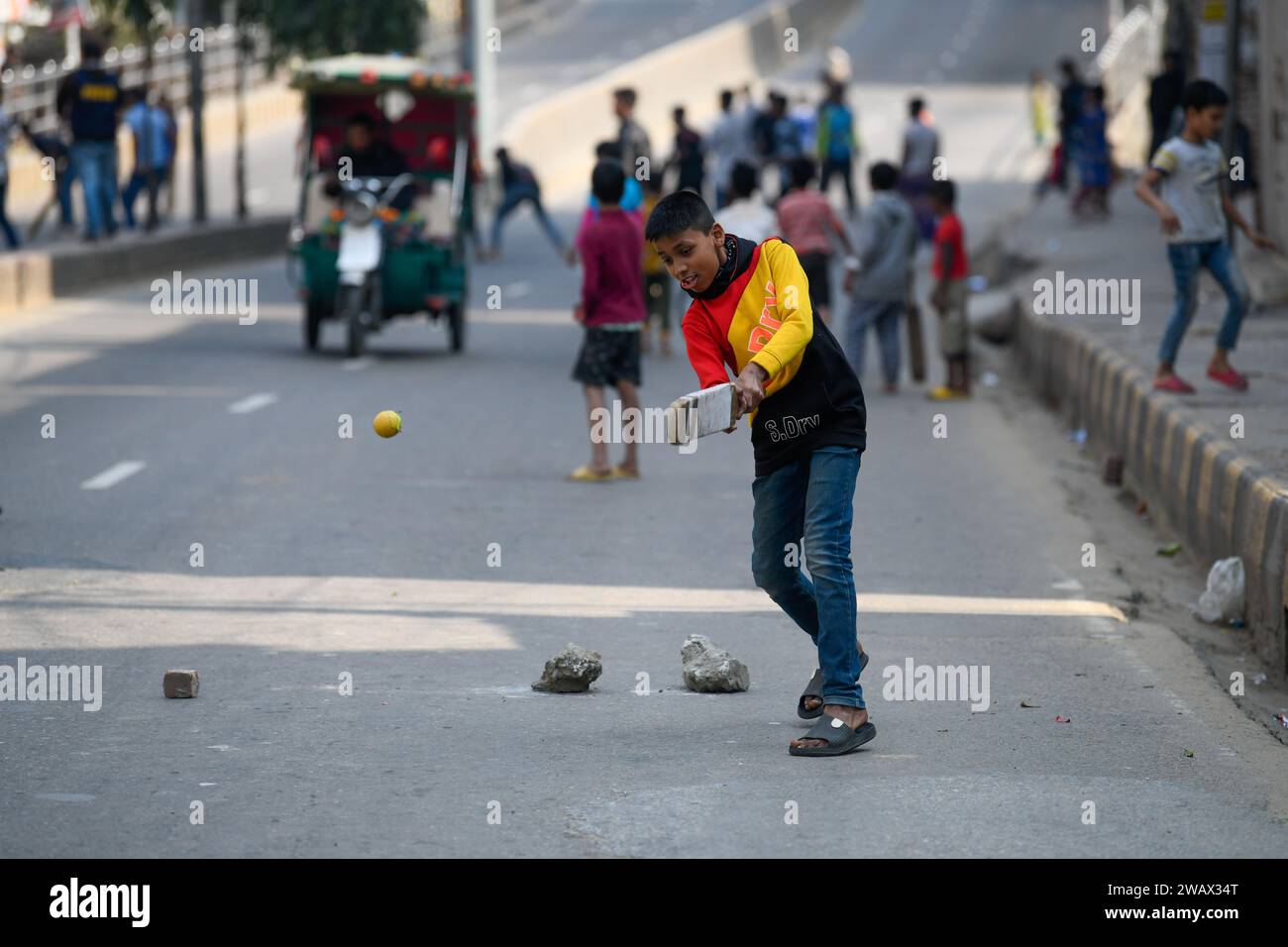 Dhaka, Bangladesch. Januar 2024. Kinder spielen am Wahltag auf einer leeren Straße Cricket. (Foto: Piyas Biswas/SOPA Images/SIPA USA) Credit: SIPA USA/Alamy Live News Stockfoto
