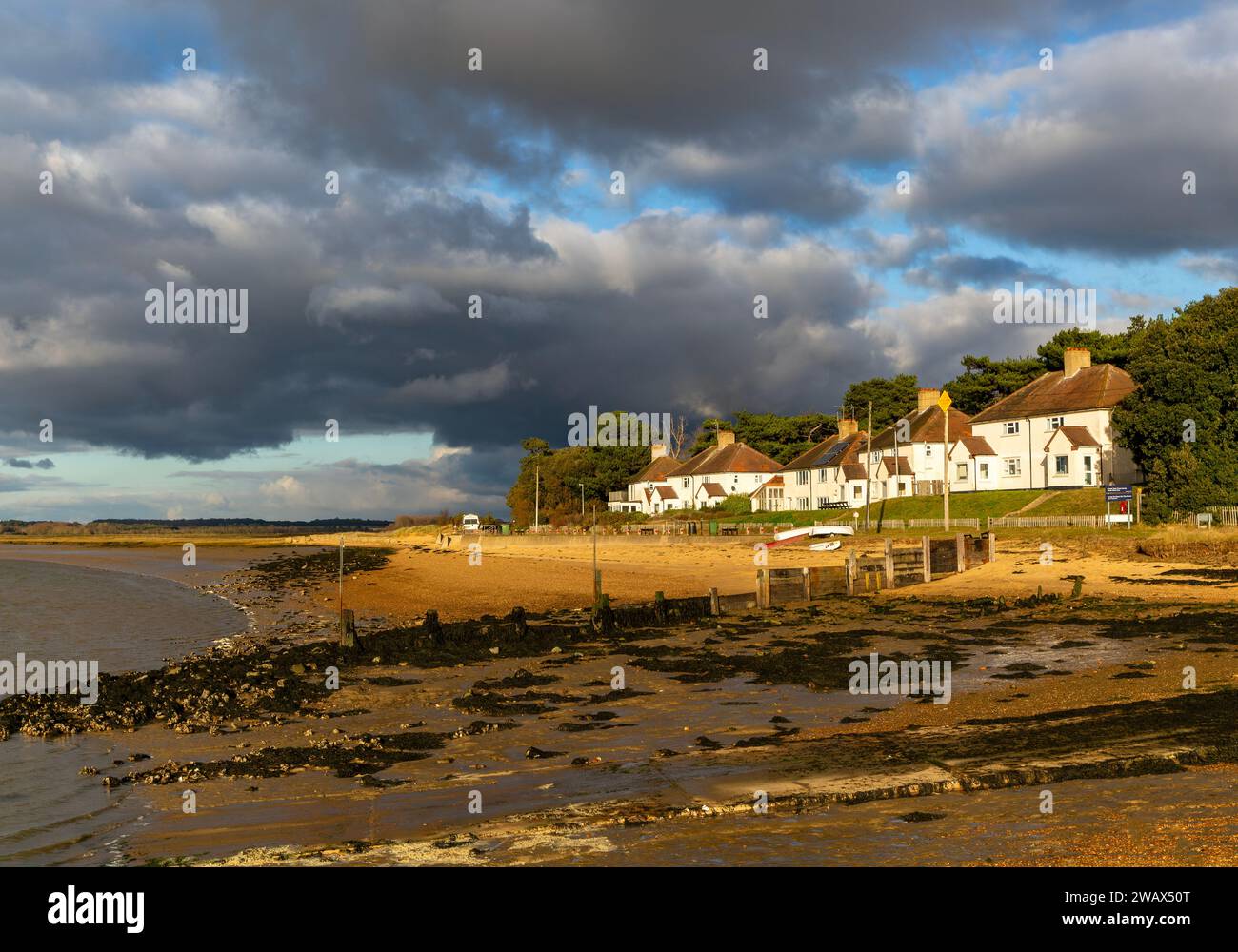 Sturmwolken über Strand und Gebäude am Bawdsey Quay, Suffolk, England, Großbritannien Stockfoto