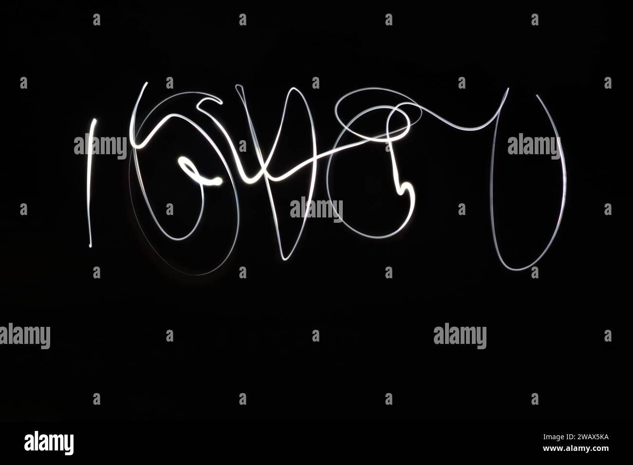 Lichtmalerei mit der Schreibweise „I love U“ in weißem Schriftzug auf schwarzem Hintergrund. Valentinstag-Nachricht. Stockfoto