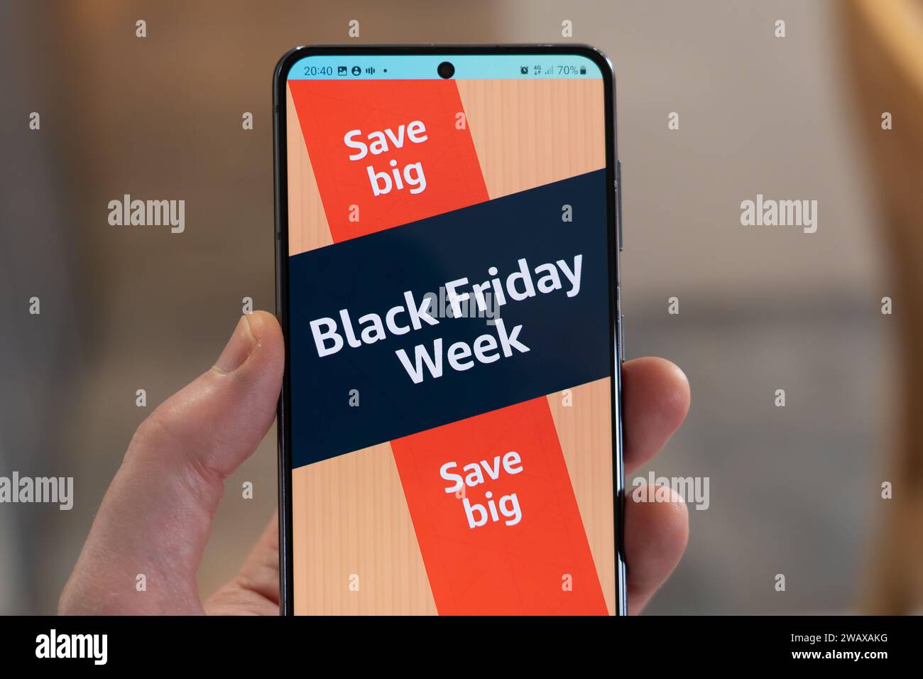 Black Friday Week mit Werbebanner und Seite aus der Amazon Shopping App auf einem Smartphone, das von einer Hand gehalten wird, UK Stockfoto