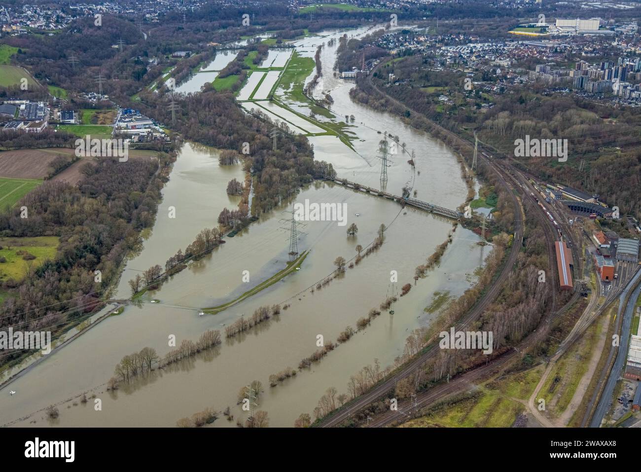 Luftbild, Ruhrhochwasser, Weihnachtshochwasser 2023, Fluss Ruhr tritt nach starken Regenfällen über die Ufer, Überschwemmungsgebiet am Eisenbahnmuseum Bochum, Eisenbahnbrücke und überschwemmte Radbrücke, Bäume und Strommasten im Wasser, hinten das Wasserkraftwerk Horster Mühle mit Schleuse Horst, Dahlhausen, Bochum, Ruhrgebiet, Nordrhein-Westfalen, Deutschland ACHTUNGxMINDESTHONORARx60xEURO *** Luftansicht, Ruhrflut, Weihnachtsflut 2023, Ruhr überquert nach starkem Regen sein Ufer, überflutetes Gebiet am Bochumer Eisenbahnmuseum, Eisenbahnbrücke und überflutete Fahrradbrücke, Bäume und Elect Stockfoto