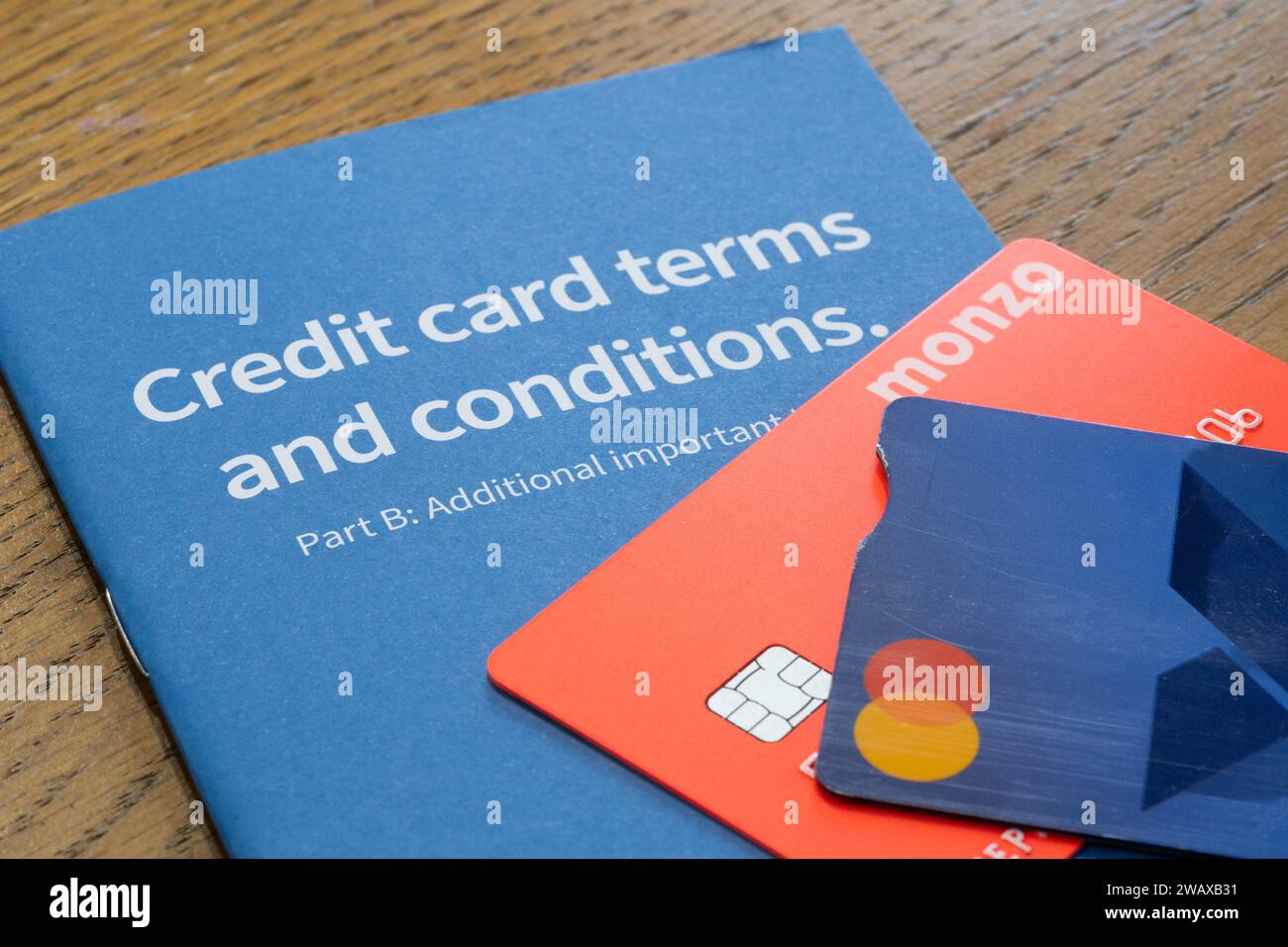 Ein Heft mit den Geschäftsbedingungen für Halifax-Kreditkarten, auf dem Kreditkarten angebracht sind. Thema: Britische Kreditkartenschulden, britische Verbraucherschulden, Kreditkartenrückzahlungen Stockfoto