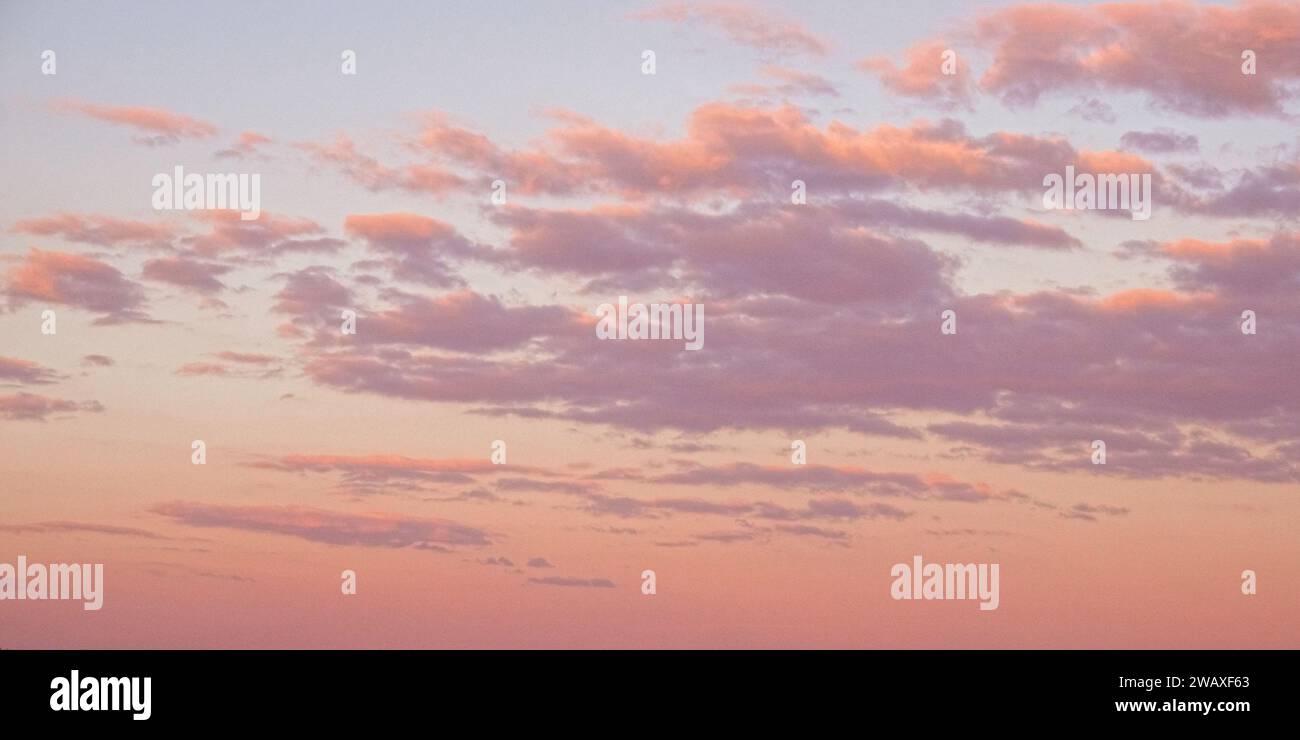 Der Himmel ist mit Wolken bemalt, die von unten sanft beleuchtet werden. Stockfoto