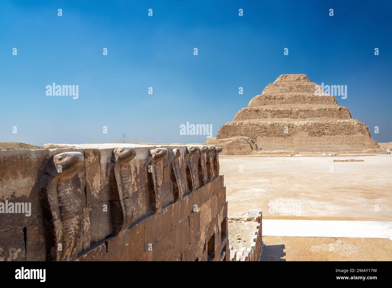 Pyramide von Djoser in Sakkara, Ägypten mit Schnitzereien von Kobras im Vordergrund Stockfoto