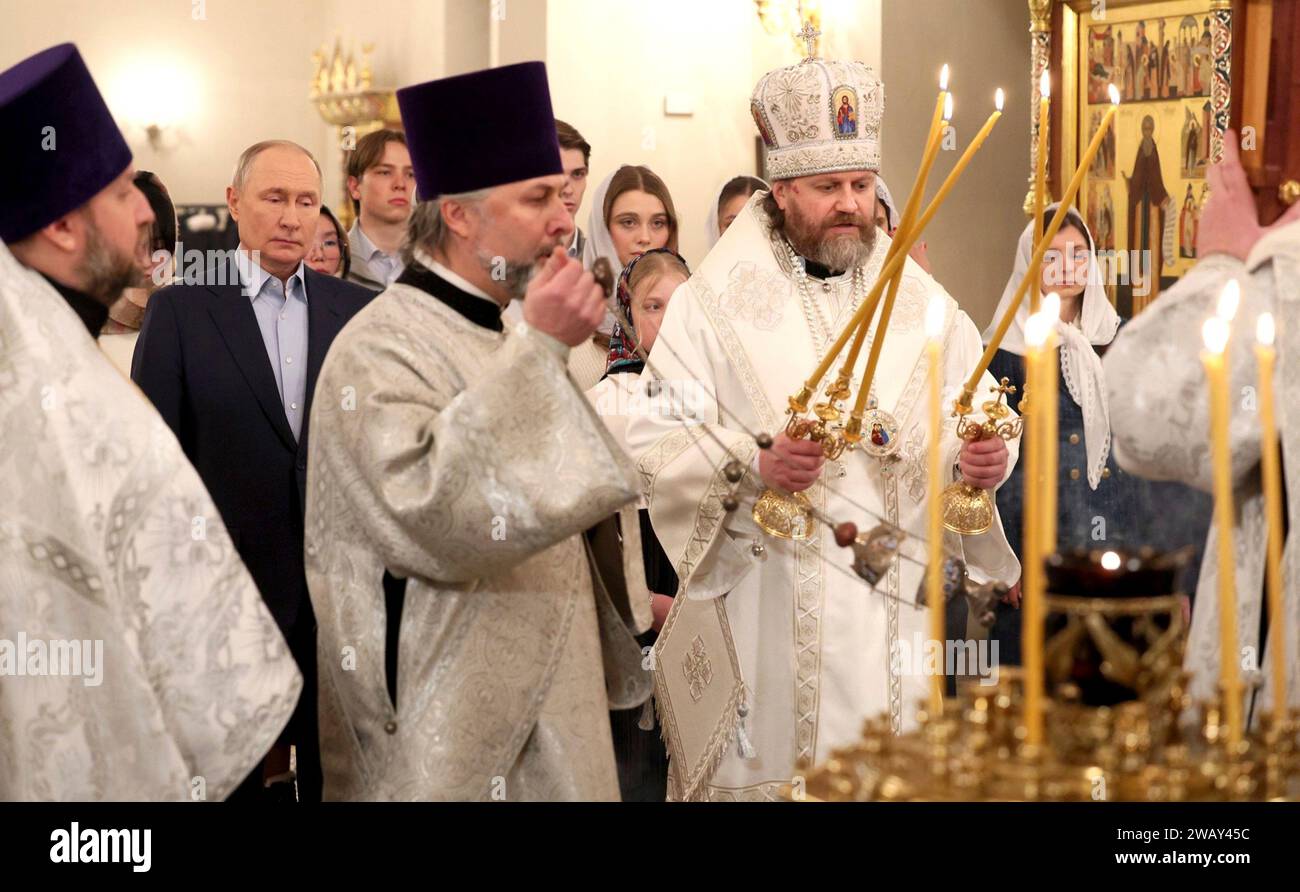 Novo-Ogaryovo, Russland. Januar 2024. Der russisch-orthodoxe Erzbischof Nikolai Mosolov zündet Kerzen während einer Weihnachtsmesse mit Präsident Wladimir Putin in der Kirche der Ikone des Erlösers nicht von Händen in der offiziellen Residenz des Präsidenten am 7. Januar 2024 in Novo-Ogarjowo, Oblast Moskau, Russland. Putin beherbergte Familien von Soldaten, die im Ukraine-Krieg getötet wurden. Quelle: Gavriil Grigorov/Kreml Pool/Alamy Live News Stockfoto