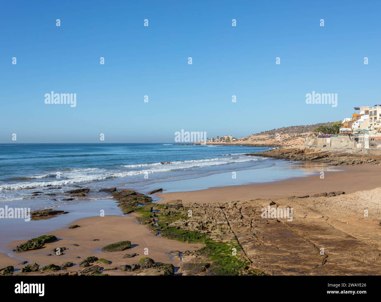 Ein Weitwinkelblick auf eine Bucht in Taghazout, in der Nähe von Agadir, mit Sand- und felsigem Strand mit Blick auf den Atlantik Stockfoto