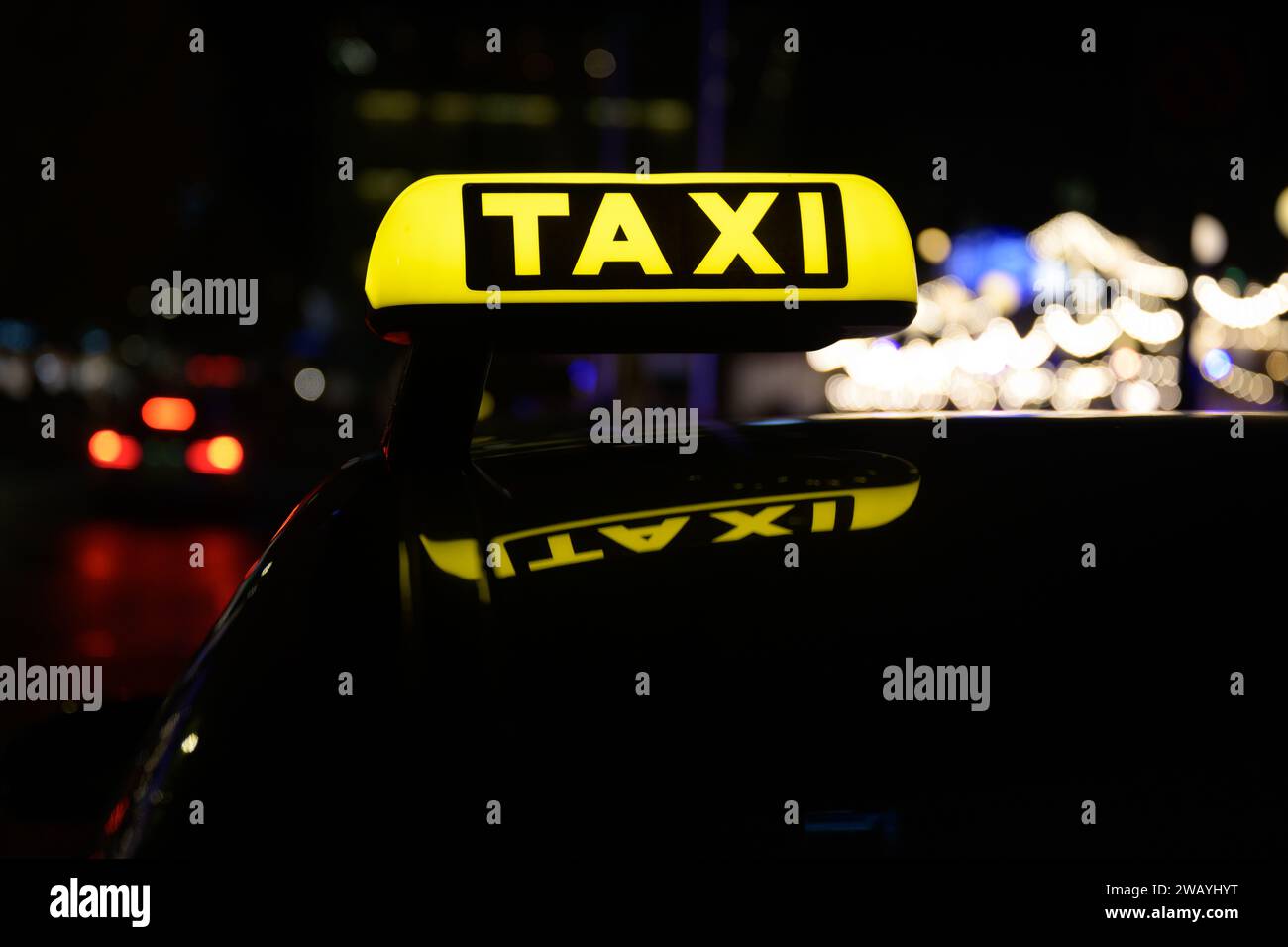 Ein gelbes Taxischild, das vom Tageslicht beleuchtet wird und auf der Rückseite eines Fahrzeugs angebracht ist und für Transportdienste bereit ist Stockfoto