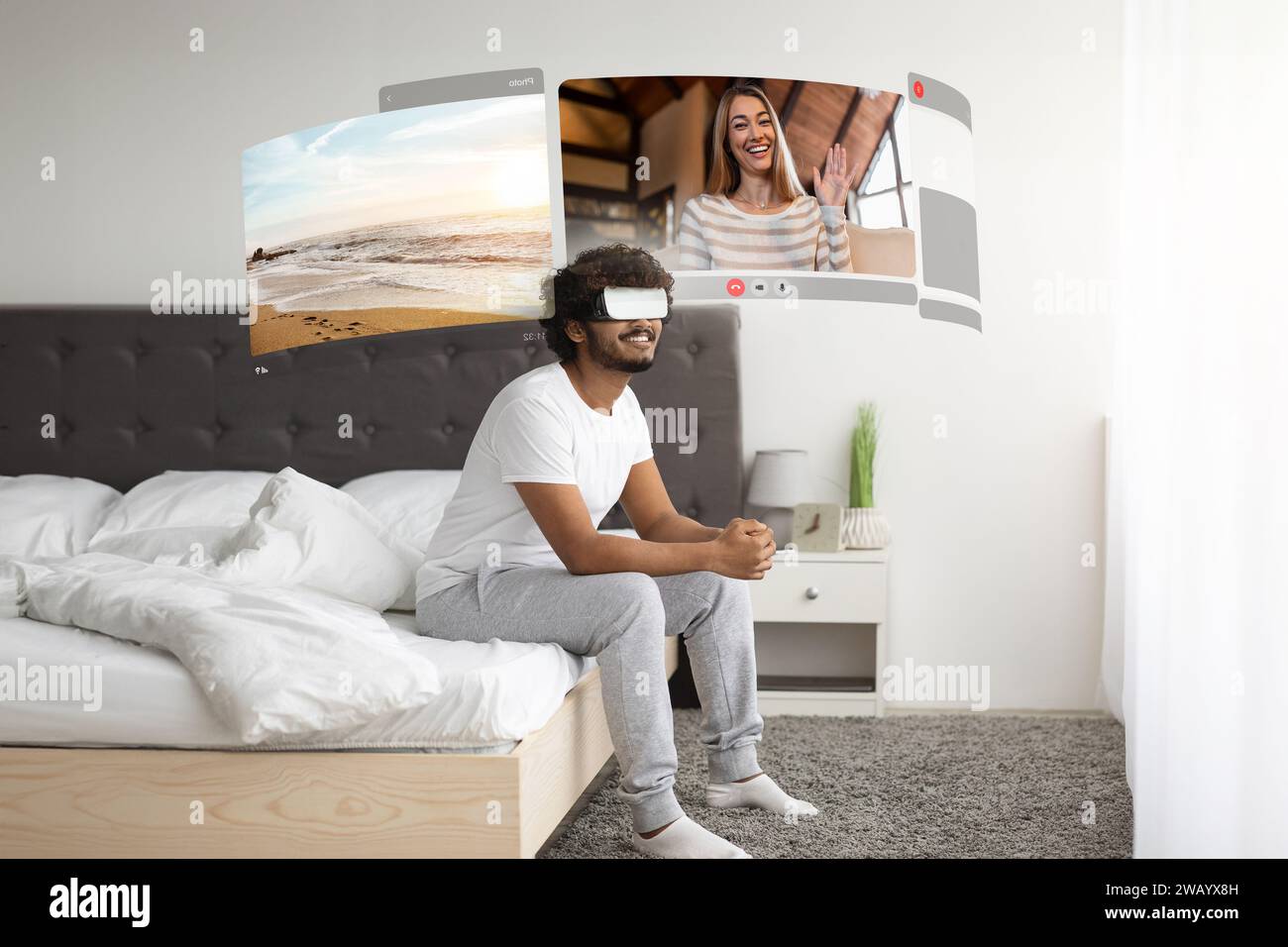 Der junge Mann nutzt VR, um Video-Chats mit seiner weit lebenden Freundin zu bereichern und sich morgens zu Hause auf dem Bett auszuruhen Stockfoto