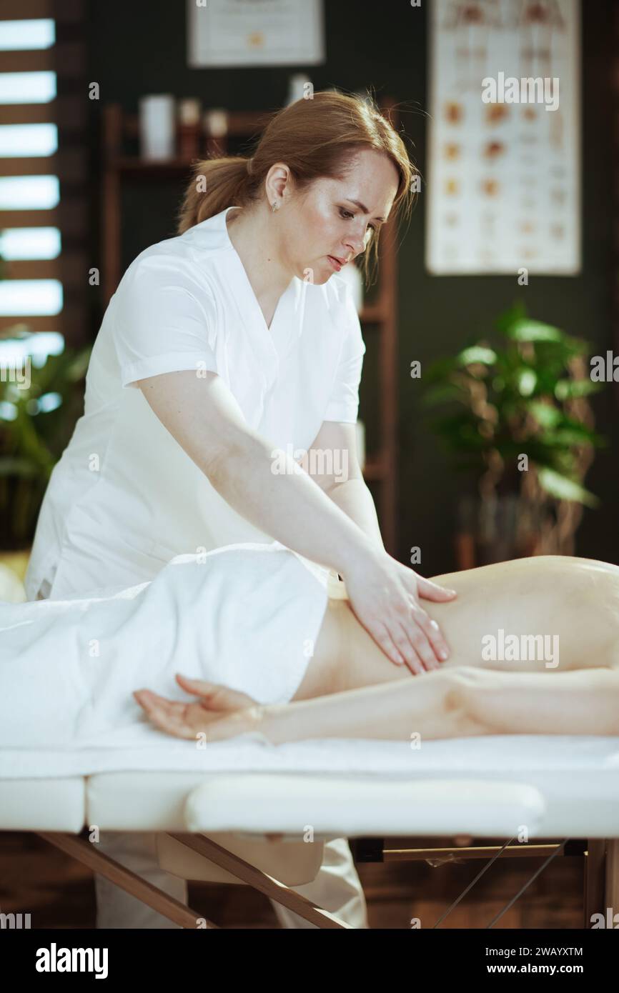 Gesundheitszeit. Medizinischer Massagetherapeut im Spa-Salon Massagekunde auf Massagetisch. Stockfoto