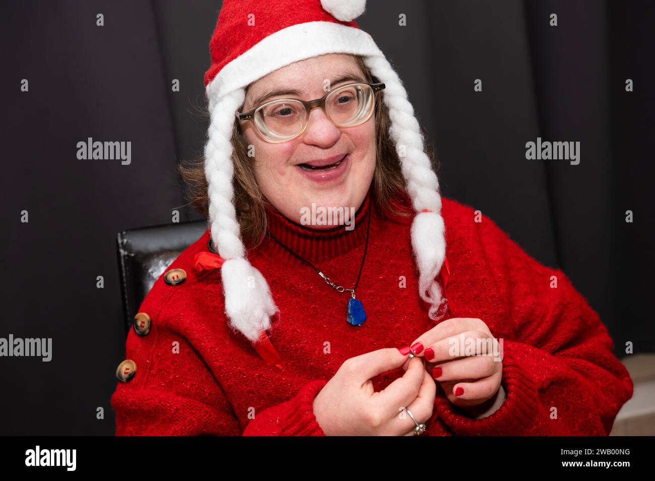 41-Jährige Frau mit Down-Syndrom, gekleidet als Weihnachtsmann zu Hause, Brüssel, Belgien Stockfoto