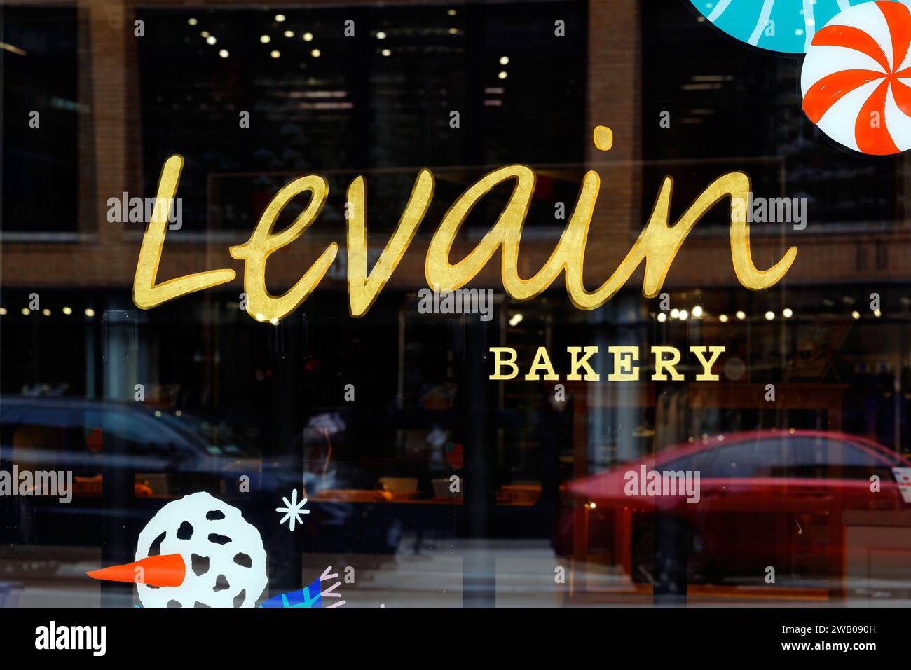 Fensterschilder in einer Levain Bakery in New York. Die Bäckerei ist spezialisiert auf dick geschnittene Schokoladen-Chips-Kekse Stockfoto