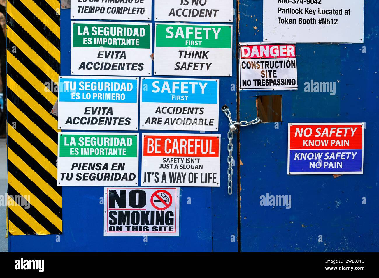 Sicherheitsschilder in englischer und spanischer Sprache, die an einer Tür zu einer Baustelle angebracht sind. Stockfoto
