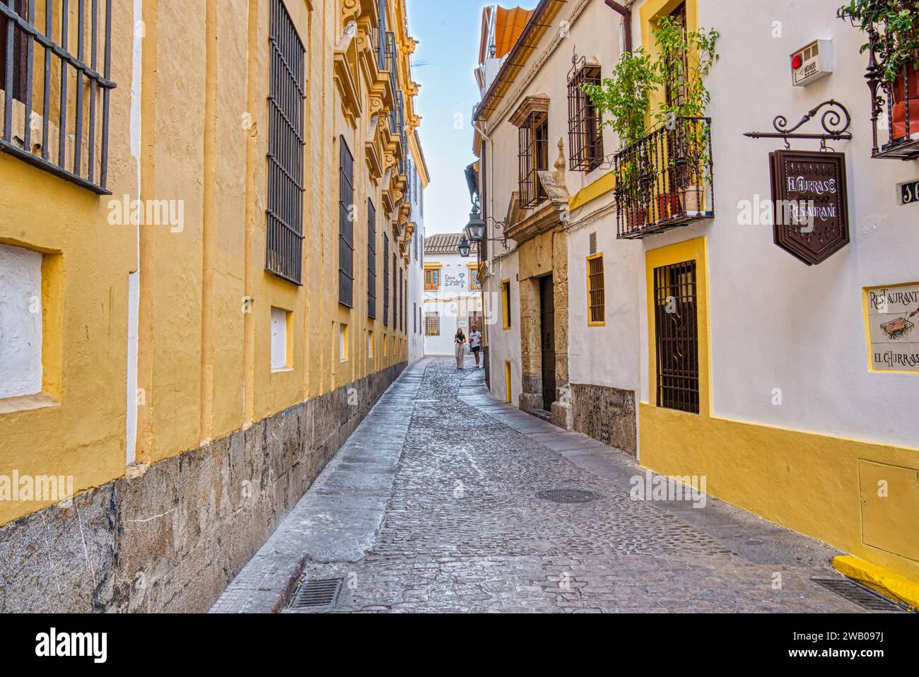 Cordoba, Spanien - 30. August 2023: Enge alte Kopfsteinpflasterstraße in der historischen Stadt Cordoba, Spanien Stockfoto
