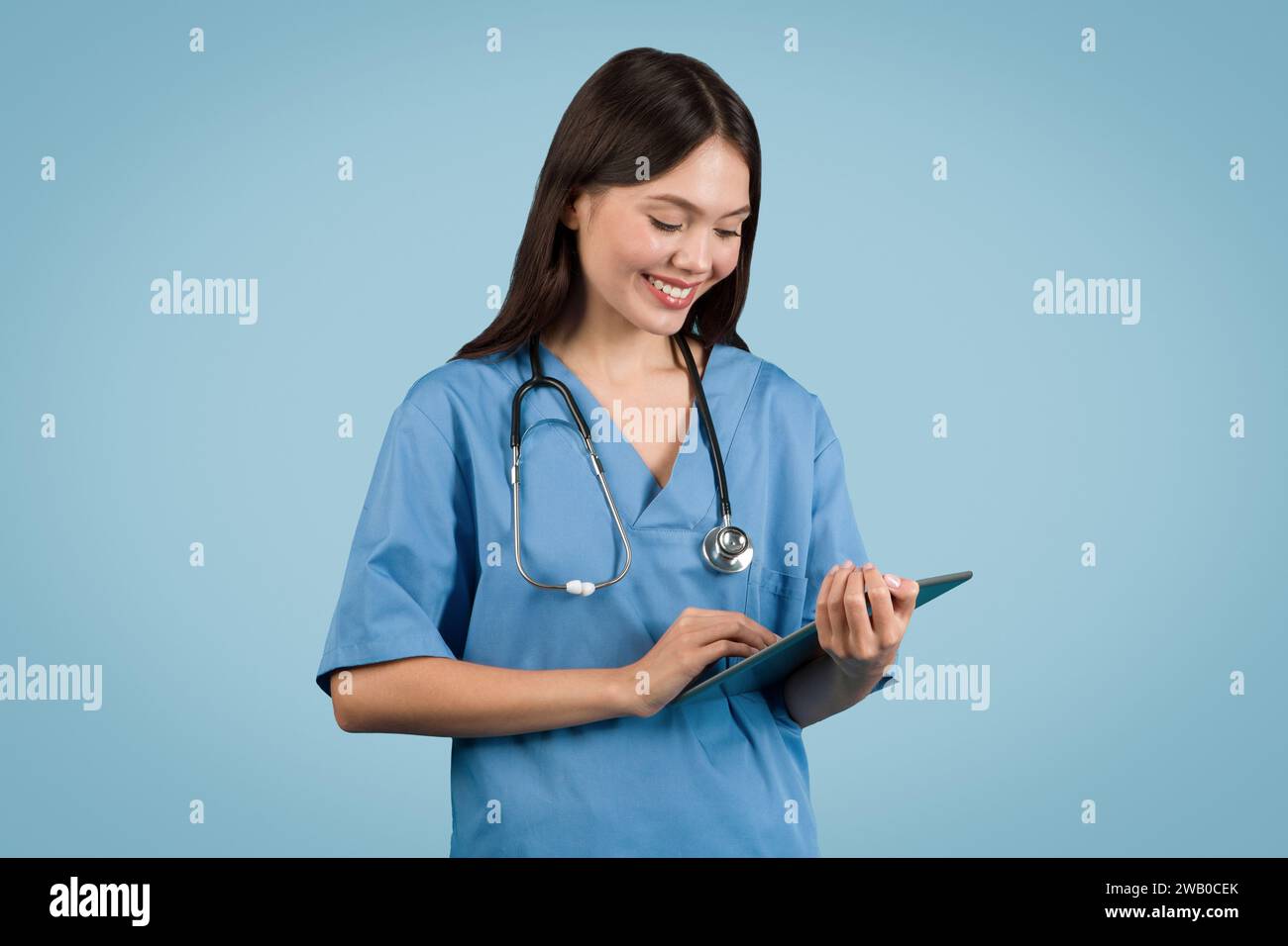 Krankenschwester in blauen Peelings mit einem Tablet, perfekt für medizintechnische Themen Stockfoto