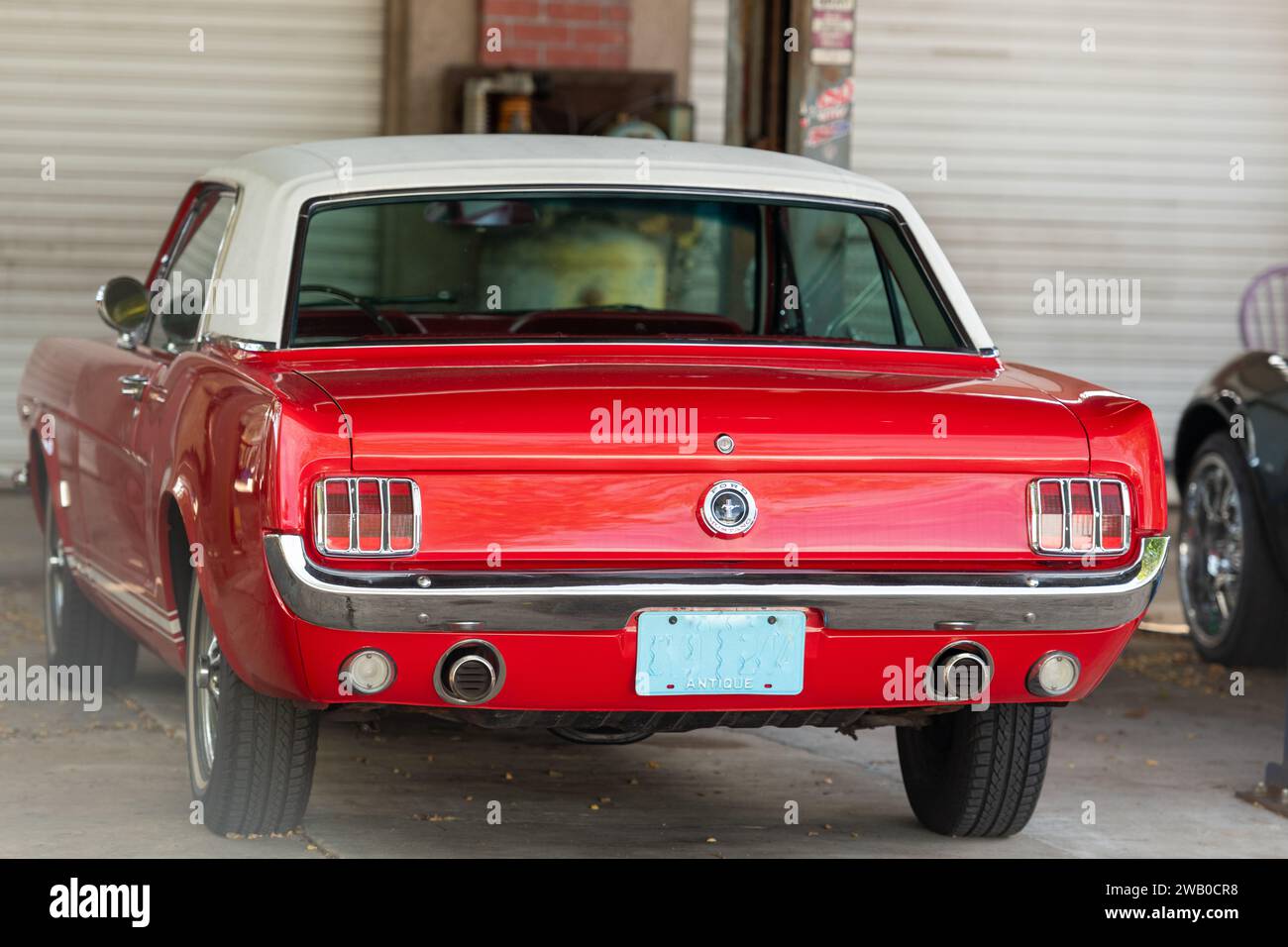 Orlando, Florida, USA-1. Januar 2024: Ein lebhaftes, apfelrotes Muscle Car, der 1965 Ford Mustang, steht in einer Garage. Stockfoto