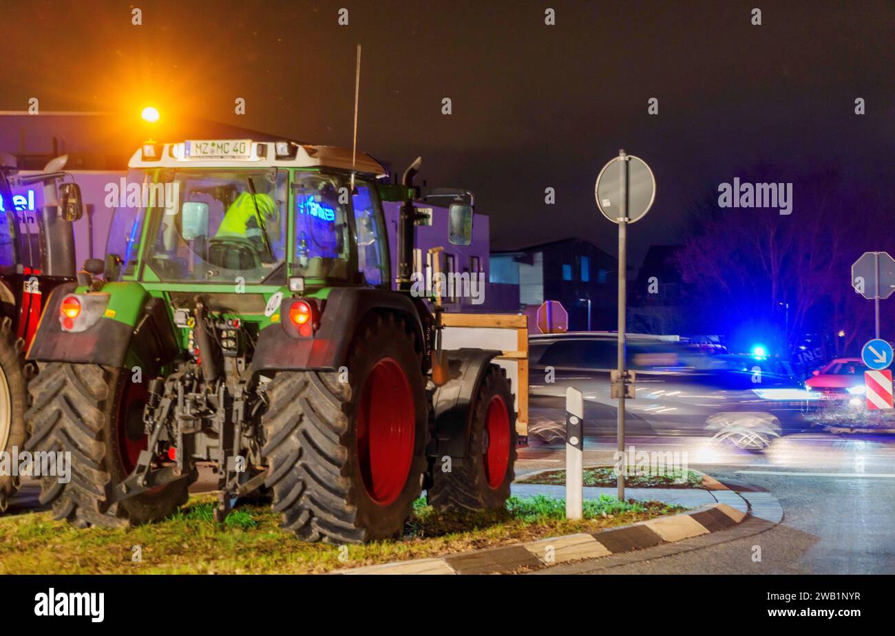 Nieder Olm, Deutschland. Januar 2024. Bauern blockieren mit ihren Traktoren die Autobahnzufahrt zur A63 in Klein-Winternheim. Als Reaktion auf die Sparpläne der Bundesregierung hat der Bauernverband eine Aktionswoche mit Kundgebungen und Kundgebungen ab dem 8. Januar gefordert. Am 15. Januar findet in einer großen Demonstration in Berlin statt. Darlegung: Andreas Arnold/dpa/Alamy Live News Stockfoto