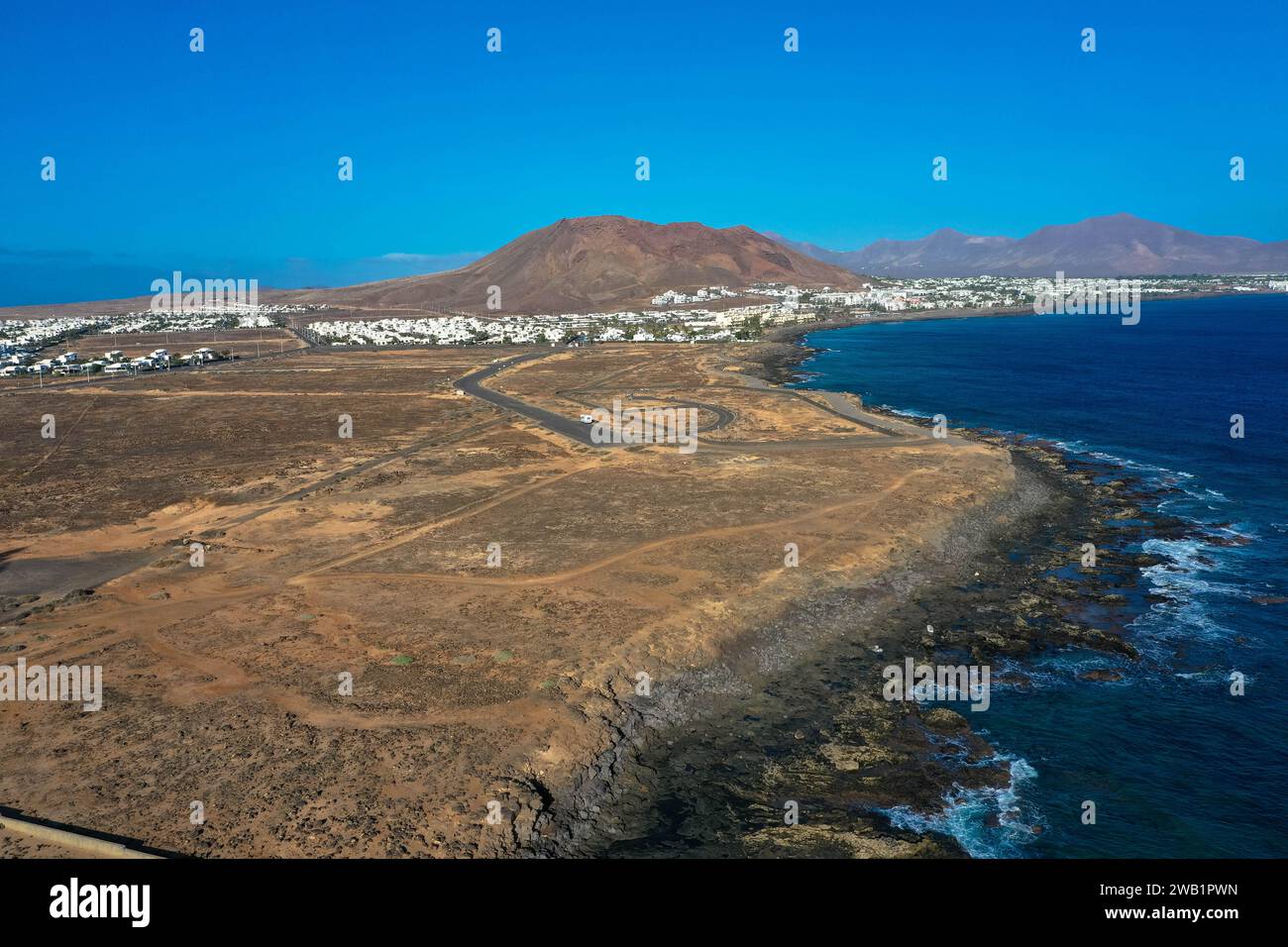 Playa Blanca Küste. Panoramablick der Drohne mit rotem Vulkan im Hintergrund. Tourismus- und Urlaubskonzept. Flamingo Beach Lanzarote, Canar Stockfoto