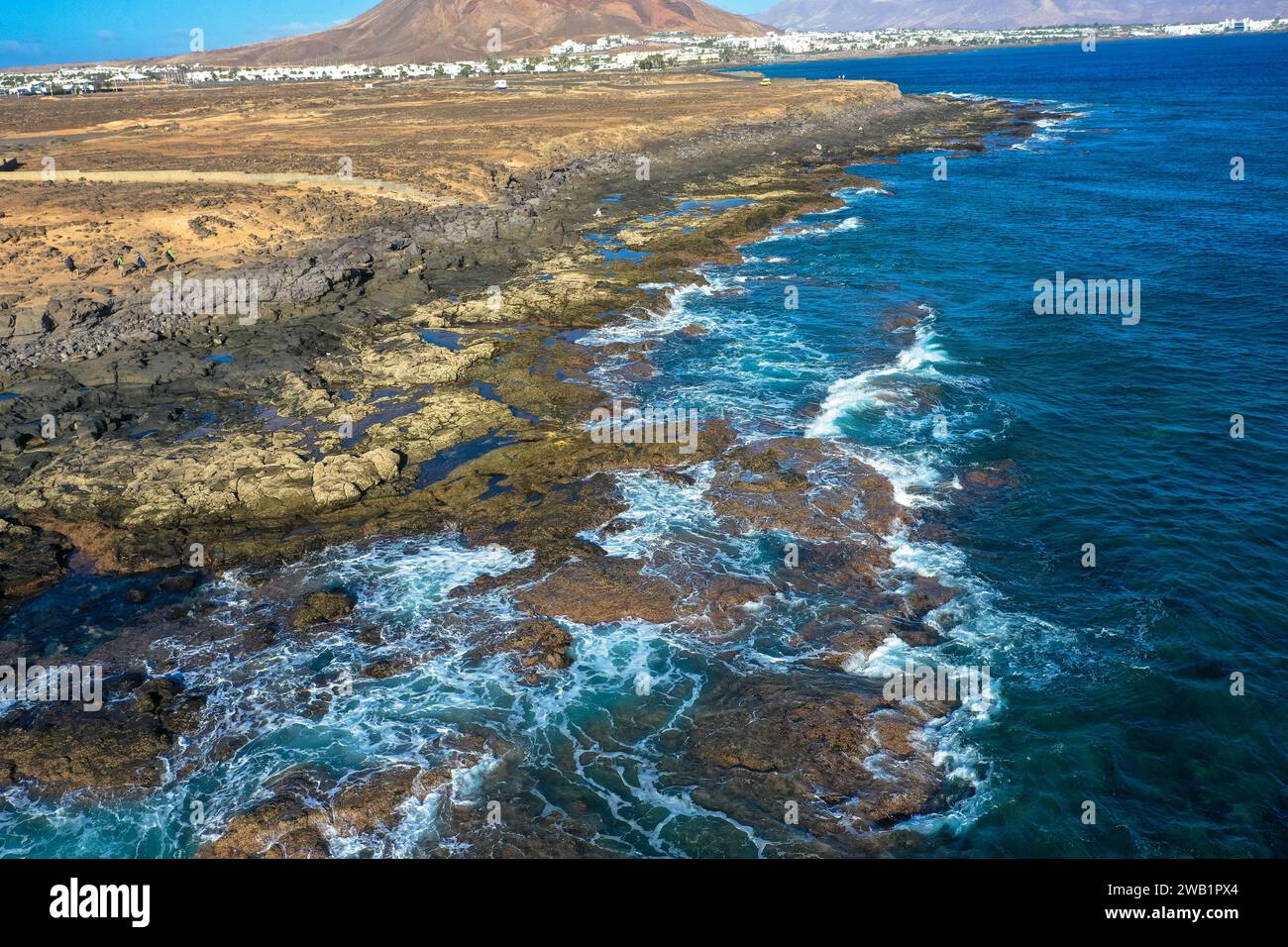 Playa Blanca Küste. Panoramablick der Drohne mit rotem Vulkan im Hintergrund. Tourismus- und Urlaubskonzept. Flamingo Beach Lanzarote, Canar Stockfoto