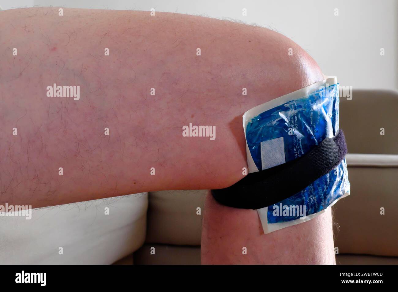 Geschwollenes Knie mit Kältepackung, nach einem Ausrutschen, München, Bayern, Deutschland Stockfoto