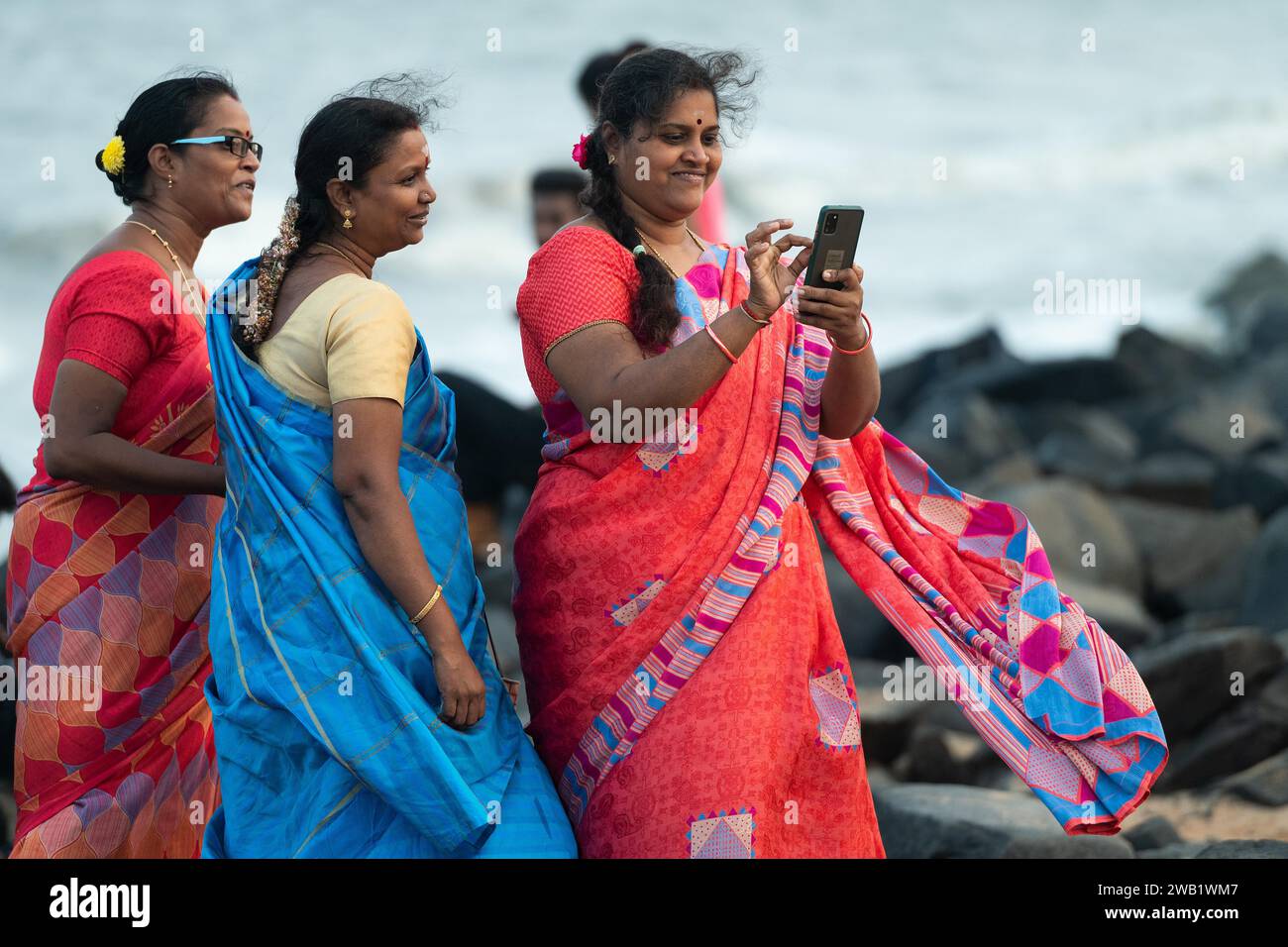 Indische Frauen in Saris am Strand, der Promenade, der ehemaligen französischen Kolonie Pondicherry oder Puducherry, Tamil Nadu, Indien Stockfoto