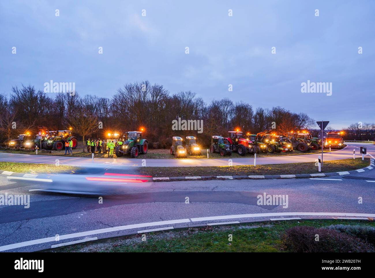 Nieder Olm, Deutschland. Januar 2024. Bauern stehen mit ihren Traktoren an einem Verkehrskreis, direkt an den Autobahnein- und -Ausfahrten zur A63 in der Gemeinde Klein-Winternheim. Als Reaktion auf die Sparpläne der Bundesregierung hat der Bauernverband eine Aktionswoche mit Kundgebungen und Kundgebungen ab dem 8. Januar gefordert. Am 15. Januar wird es in einer großen Demonstration in der Hauptstadt enden. Darlegung: Andreas Arnold/dpa/Alamy Live News Stockfoto
