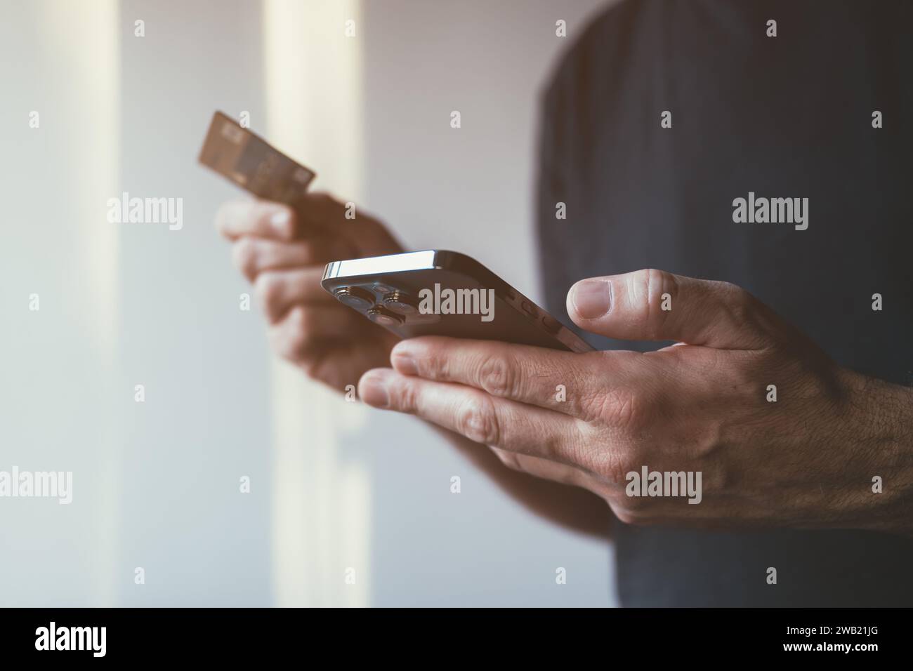 Online-Kauf von Debitkarten und Handy-App, Nahaufnahme männlicher Hände mit Smartphone, um Finanztransaktionen im Internet abzuschließen, selektiver Fokus Stockfoto