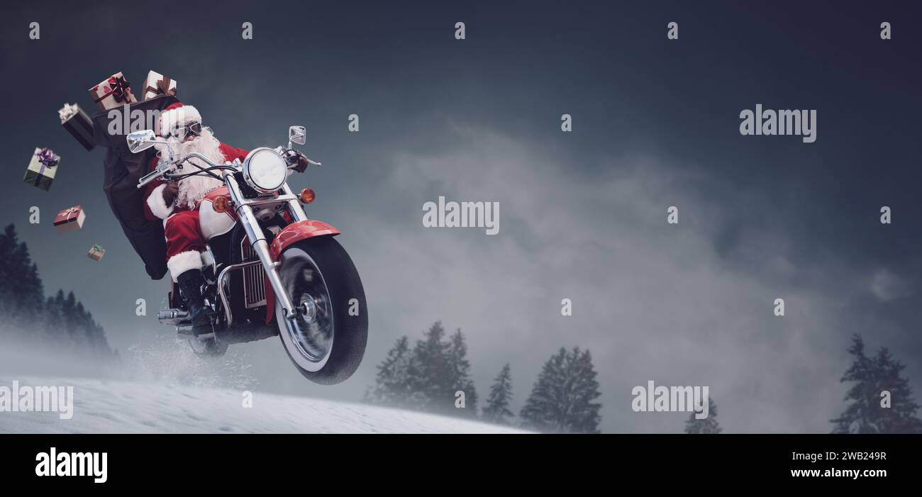 Unkonventioneller Weihnachtsmann, der auf einem schnellen Motorrad auf dem Schnee fährt und Weihnachtsgeschenke liefert Stockfoto
