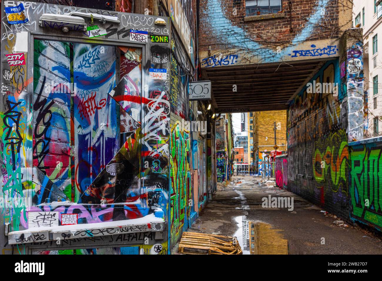 Die Graffiti Alley, auch bekannt als Rush Lane, ist ein verstecktes Juwel im Modeviertel von Toronto. Es ist eine enge Gasse, die von farbenfrohen Wandmalereien und Straßen gesäumt ist Stockfoto