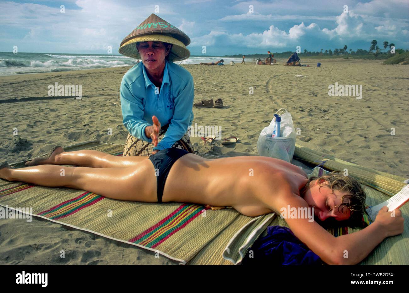 Indonesien, Bali. Der Tourist bekommt eine Massage am Strand. Stockfoto