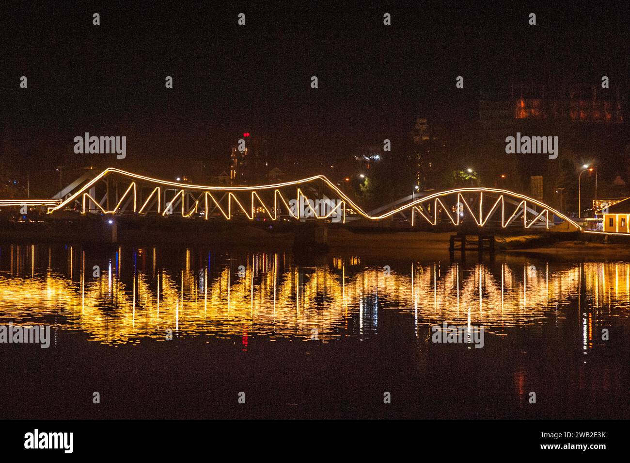 Die alte französische Brücke am Praek Tuek Chhu erleuchtete bei Nacht. Kampot, Kambodscha. © Kraig Stockfoto