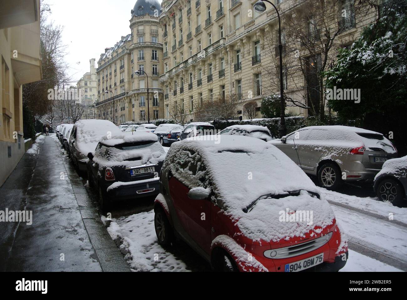 Im Februar 2018 fiel in Paris Schnee. Eine verlassene Straße mit schneebedeckten Autos. Stockfoto