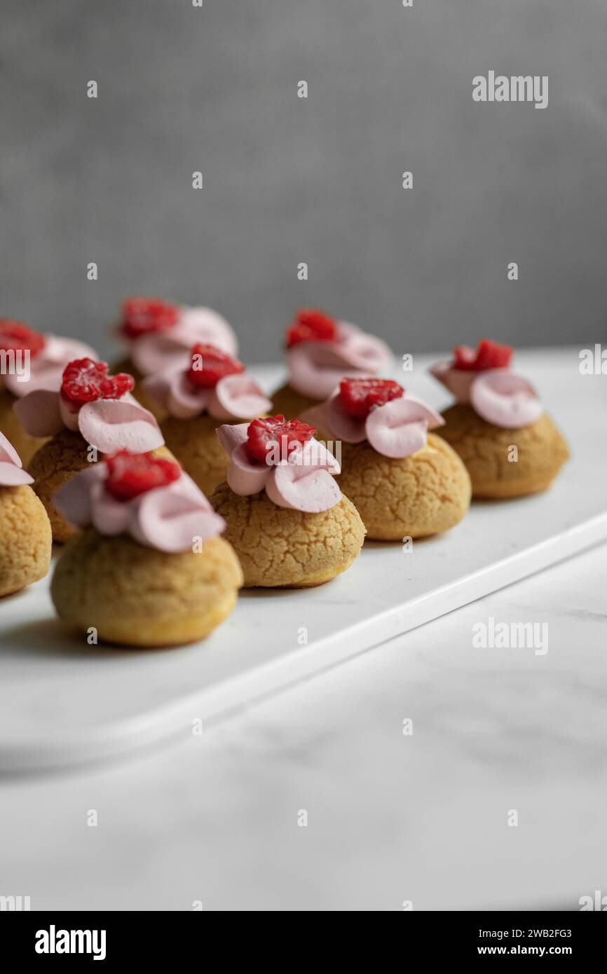 Raspberry Eclair Choux auf einem Whiteboard Stockfoto