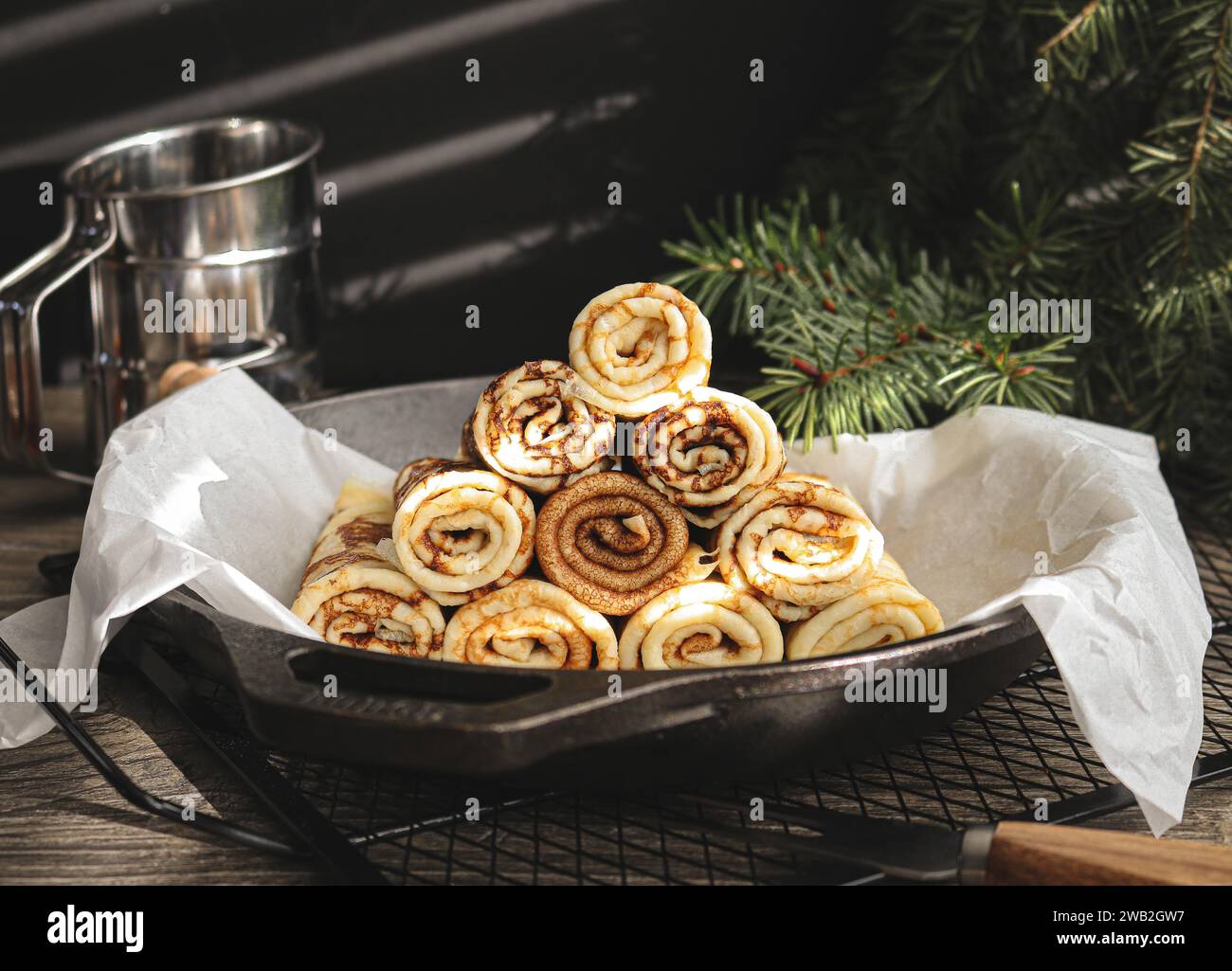 Crepes in einer schwarzen Eisenpfanne und Sonnenschein kommt durch das Fenster Stockfoto