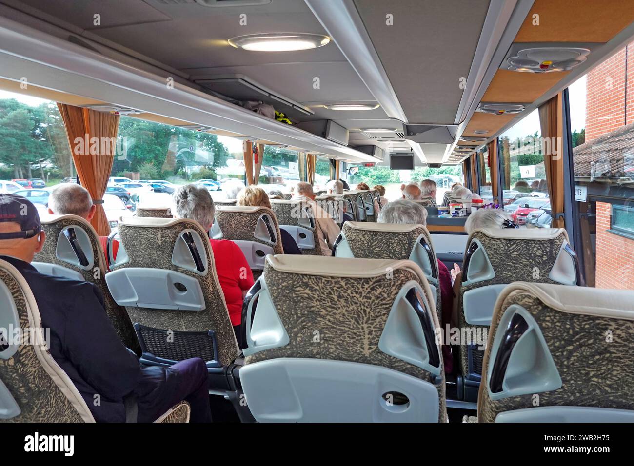 Buspassagiere Innenansicht von hinten, meist graue, ältere Köpfe, die bequem für einen Sommerurlaub im Hotel in East Anglia England, Großbritannien, sitzen Stockfoto