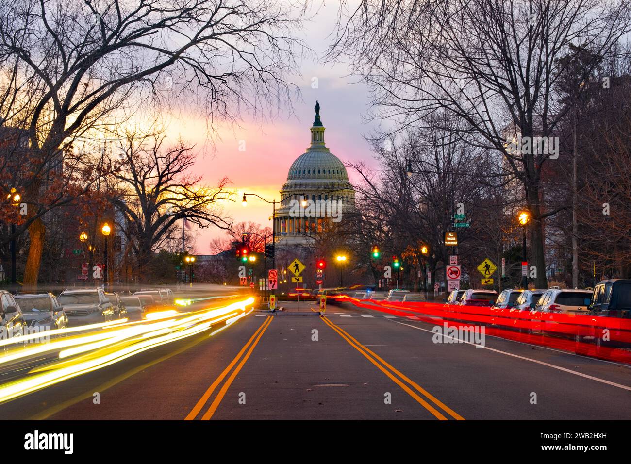 Das US Capitol Building bei Sonnenuntergang, der Verkehr bewegt sich im Vordergrund Stockfoto