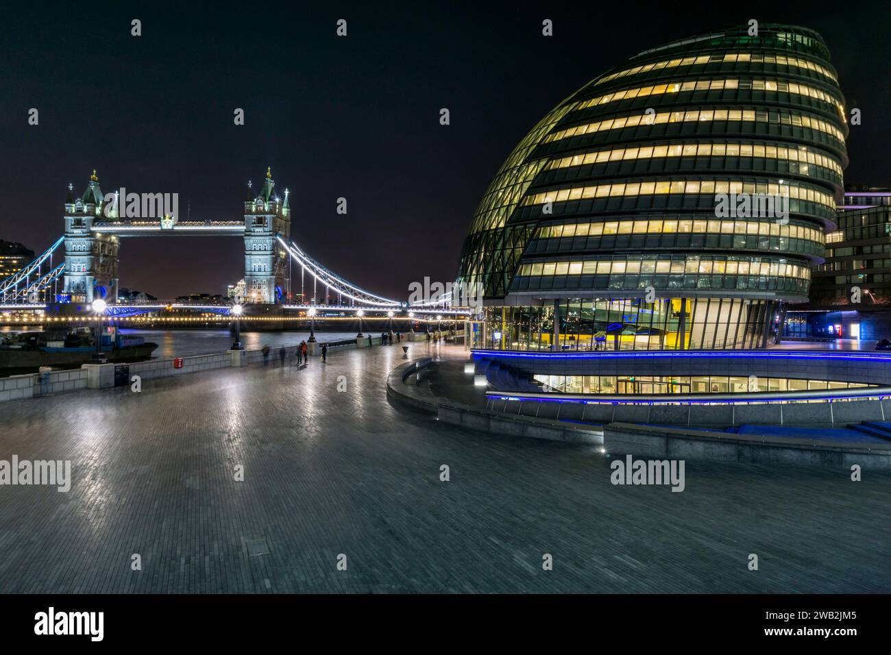 Nächtlicher Blick auf das Rathaus mit der Tower Bridge im Hintergrund. Stockfoto