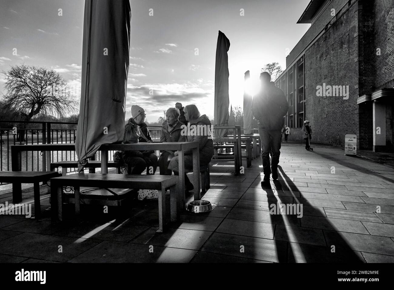 Menschen, die die Wintersonne in Stratford Upon Avon, England, Großbritannien genießen. Contra Jour, Schwarzweiß-Fotografie, Stockfoto