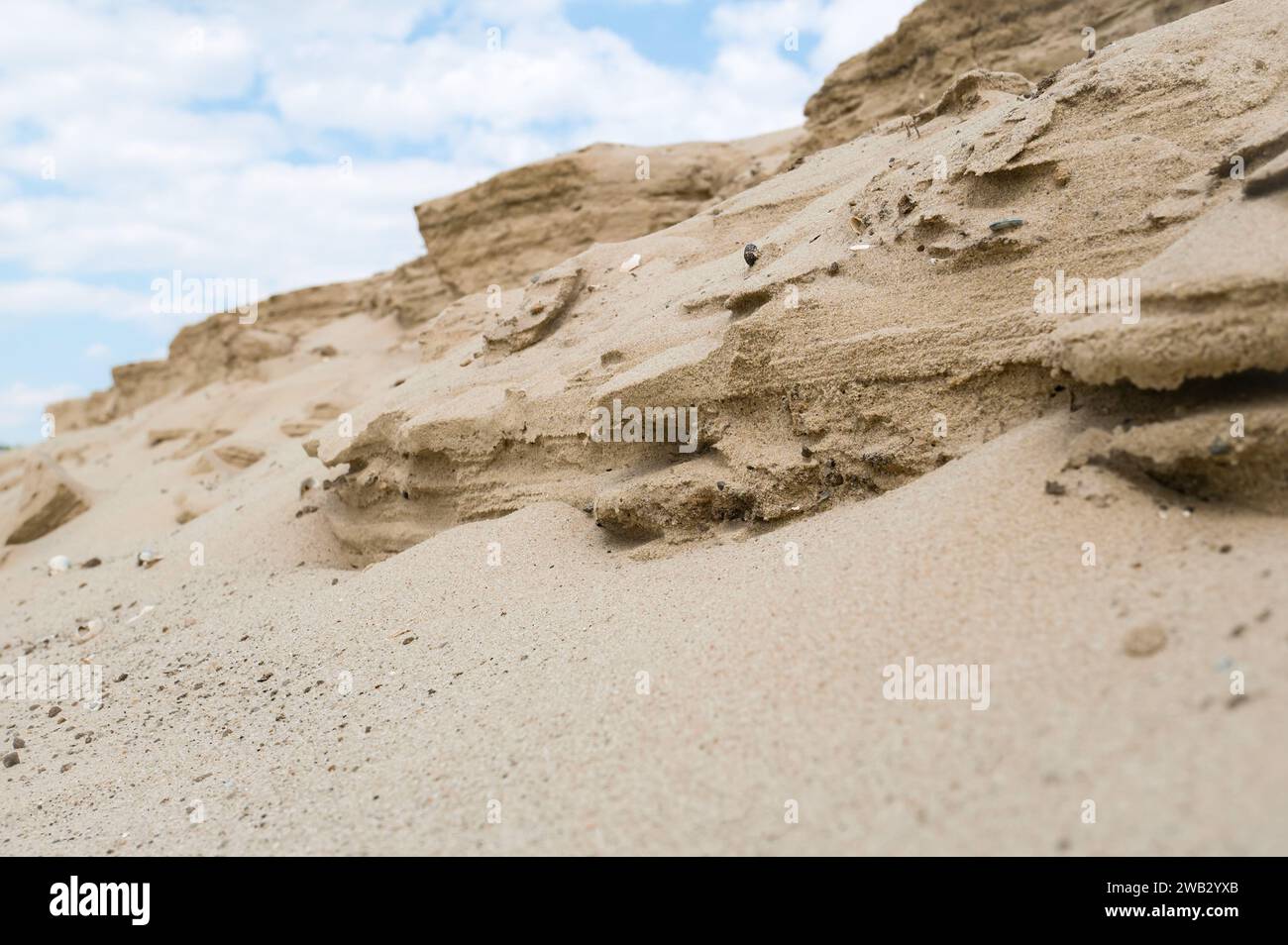 Sandformen, die durch Winderosion gegen einen blauen bewölkten Himmel entstehen Stockfoto