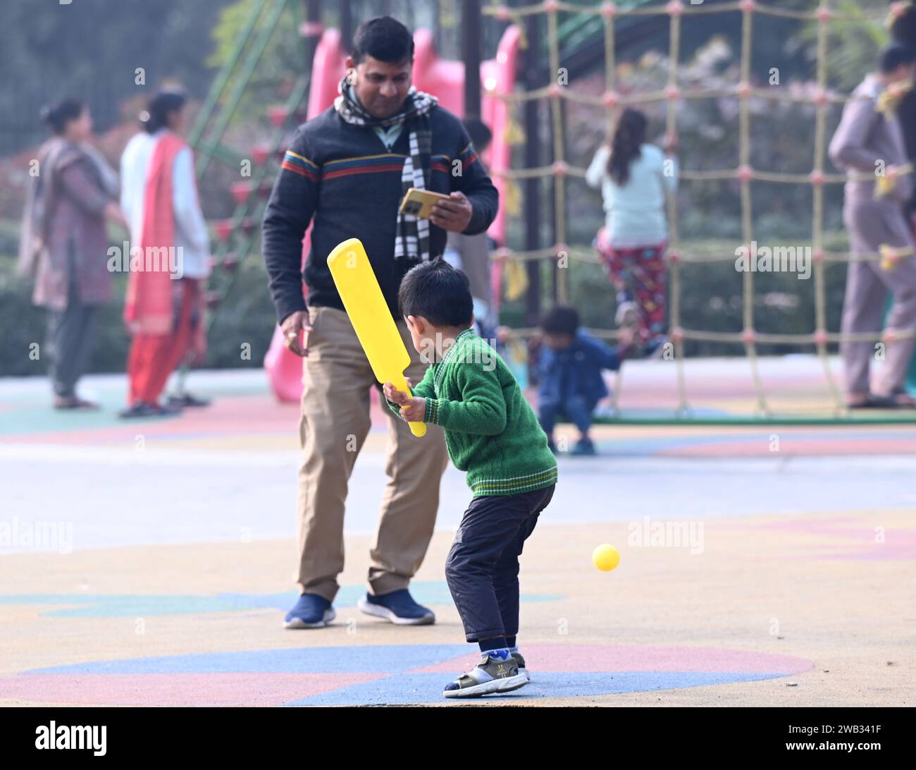 NOIDA, INDIEN - 7. JANUAR: Menschen und Kinder während sonniger Stunden an einem kalten Wintertag im Kinderpark in Sektor 33, am 7. Januar 2024 in Noida, Indien. Der Nebel am Morgen fordert Delhi-NCR mit zunehmender Kälte heraus, und Quecksilber taucht weiter in Nordindien ein. (Foto: Sunil Ghosh/Hindustan Times/SIPA USA) Credit: SIPA USA/Alamy Live News Stockfoto