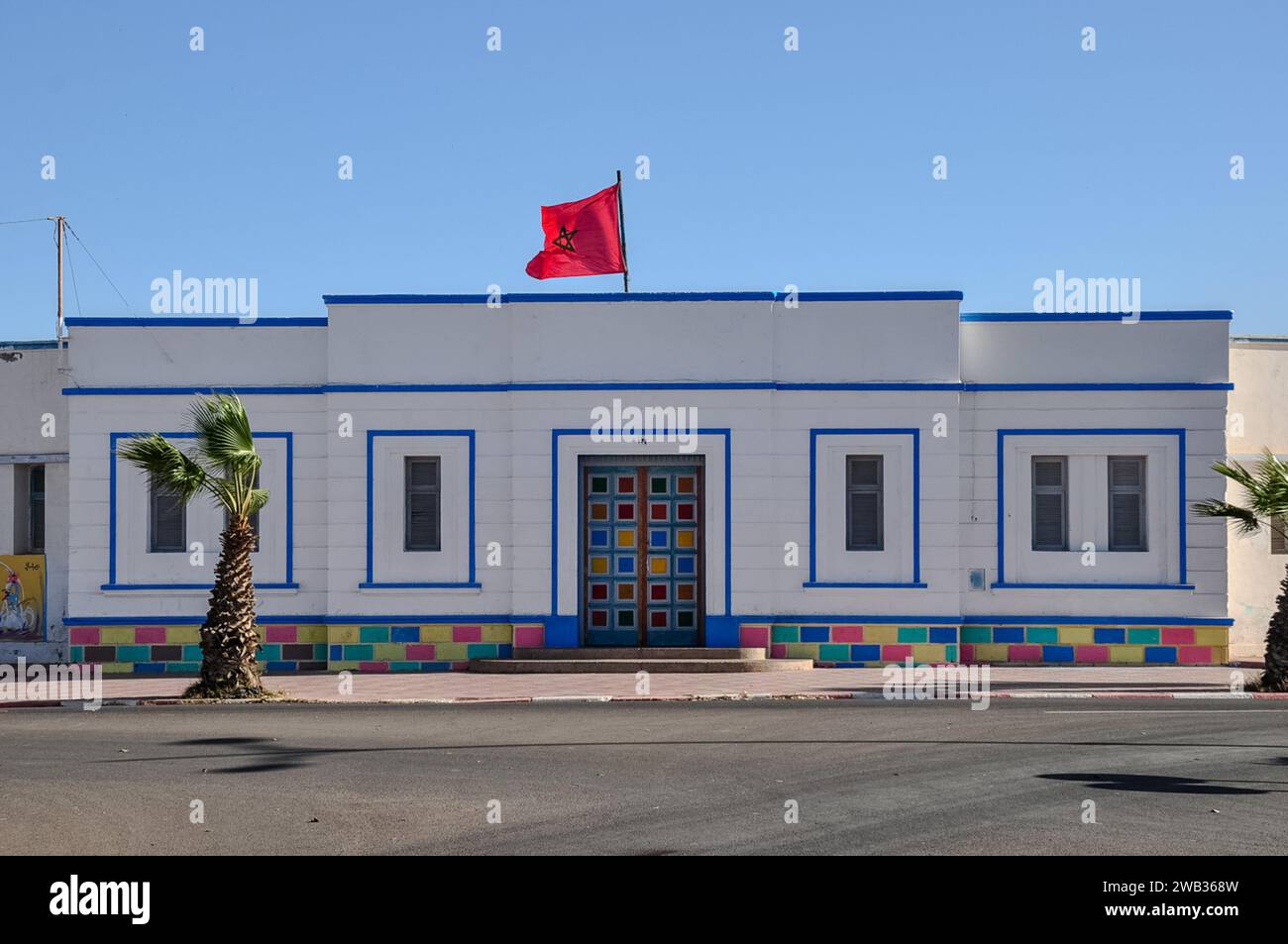 Ecole Halima Saâdia, die örtliche Schule an der Avenue Hassan II, Sidi Ifni, Marokko. Art déco-Stil, wunderschön bemalt mit marokkanischer Nationalflagge. Stockfoto