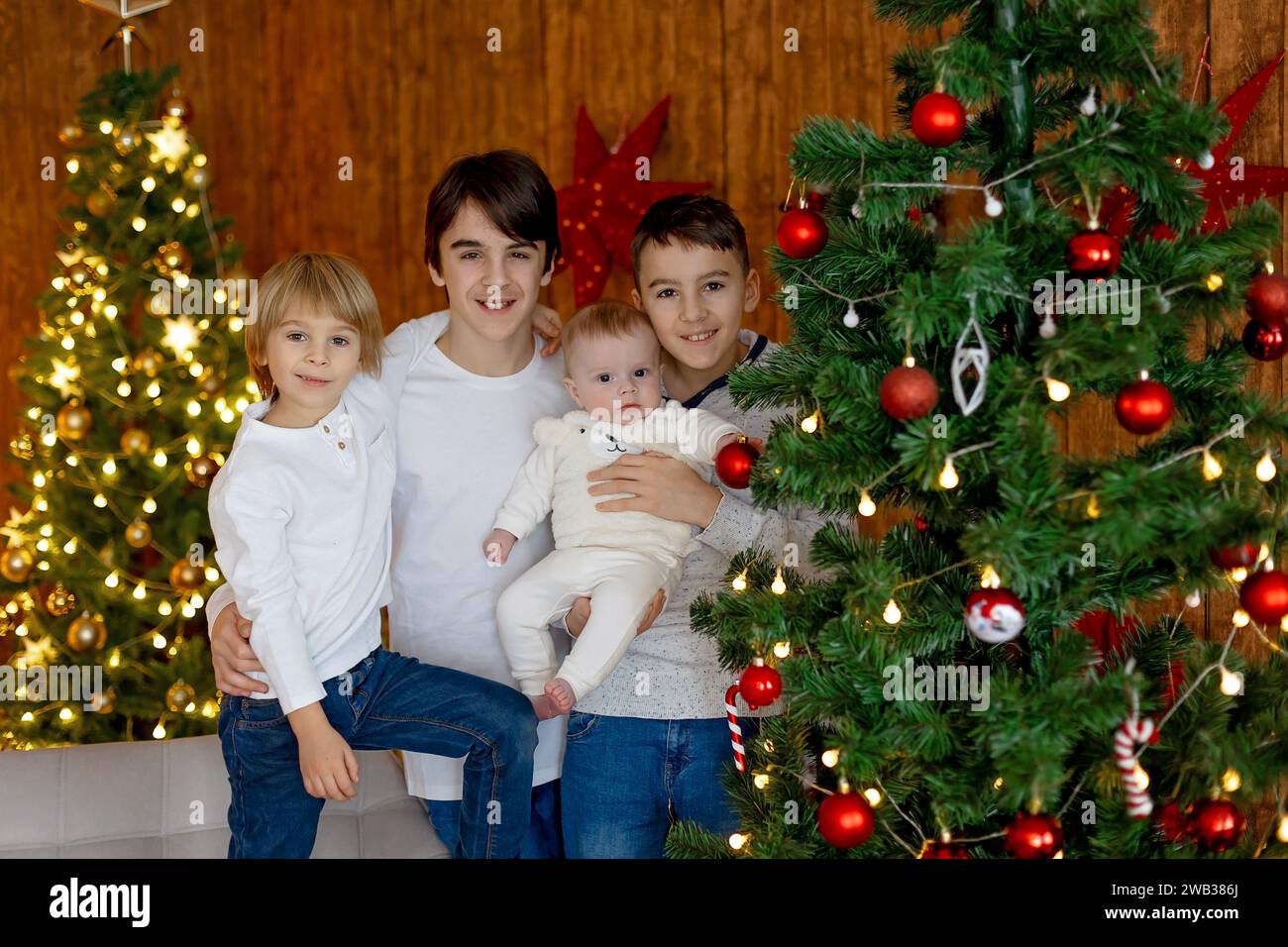 Glückliche Familie, neugeborenes Baby und ältere Brüder, Mutter zu Hause zu Weihnachten Stockfoto