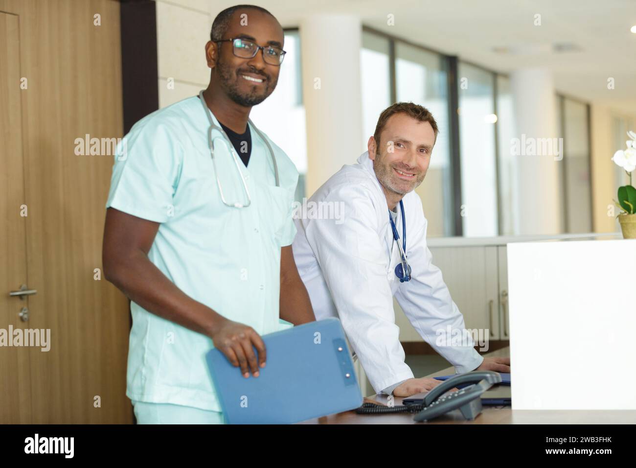 Junger Arzt, der an der Rezeption der Klinik arbeitet Stockfoto
