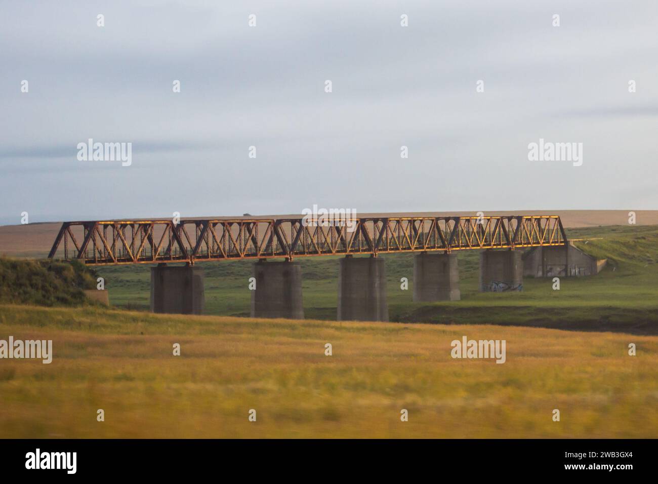 Eine alte Eisenbahnbrücke, die den Vaal River in Südafrika überquert, im frühen goldenen Licht Stockfoto