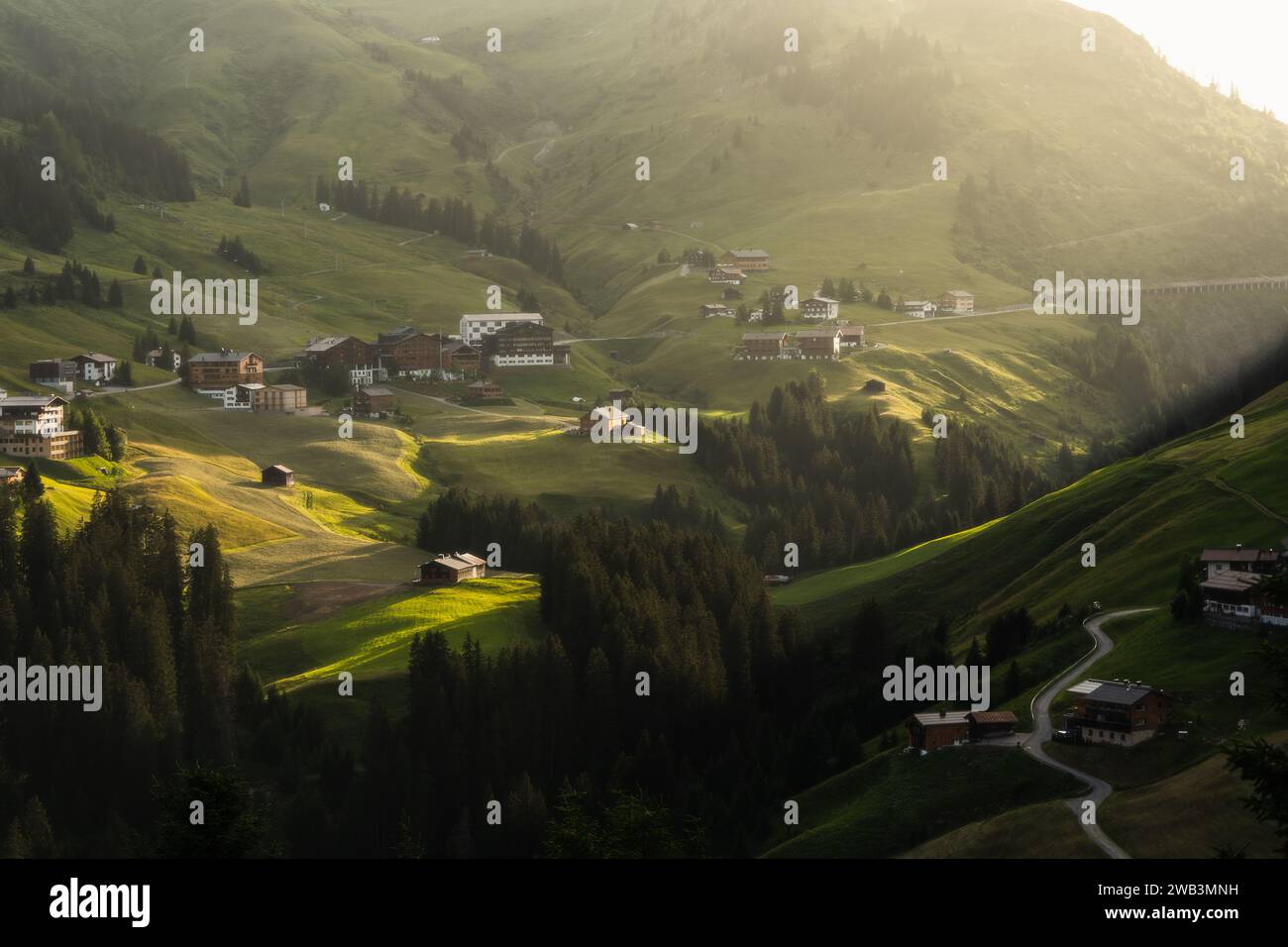 Ein malerischer Blick auf ländliche Häuser auf grünen Hügeln an einem sonnigen Tag Stockfoto