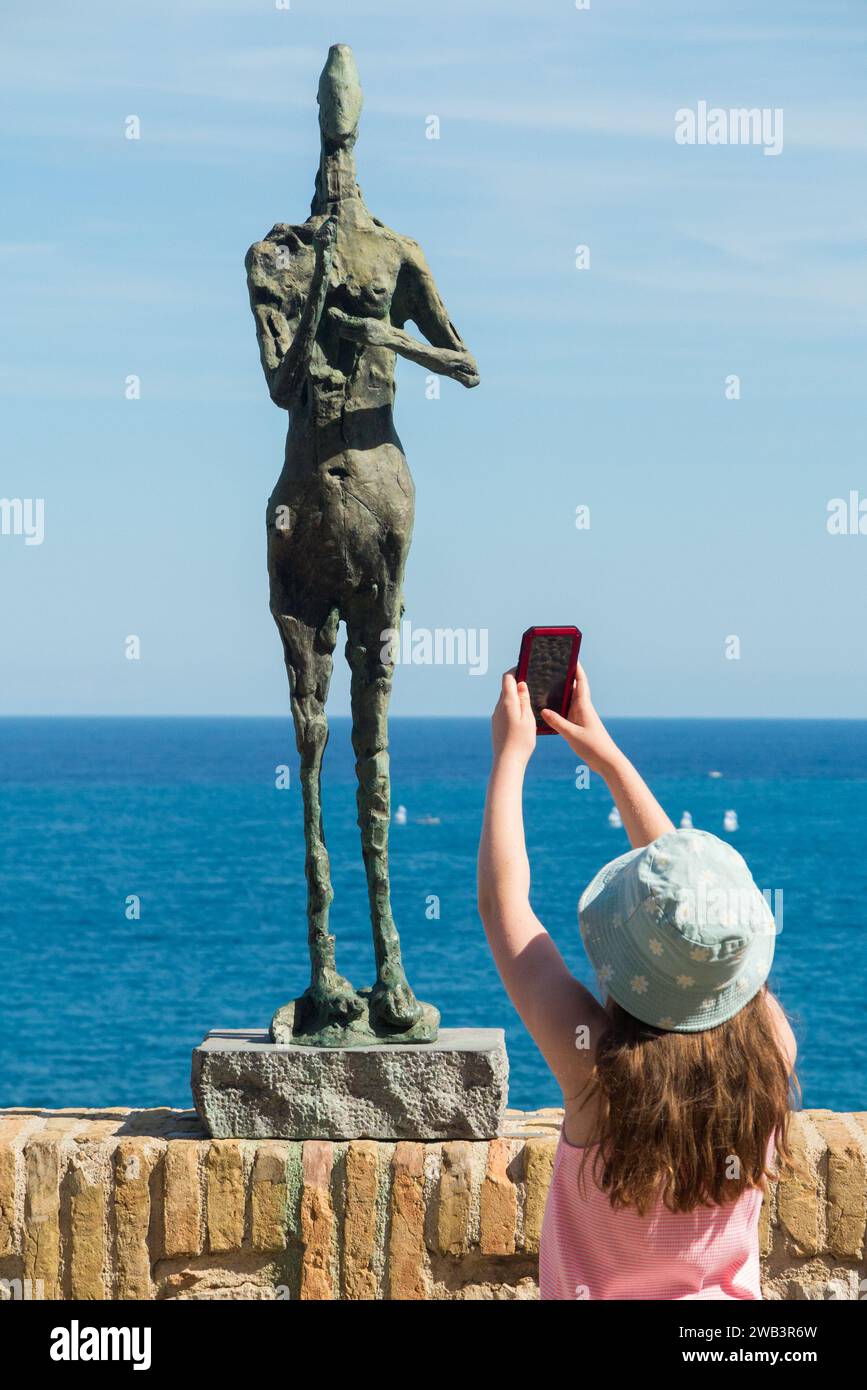 Mädchen/Kind fotografieren die Skulptur „Le Grain“ von Germaine Richier im Musée Picasso, Antibes / Musée Grimaldi - Château d'Antibes. Frankreich. (135) Stockfoto