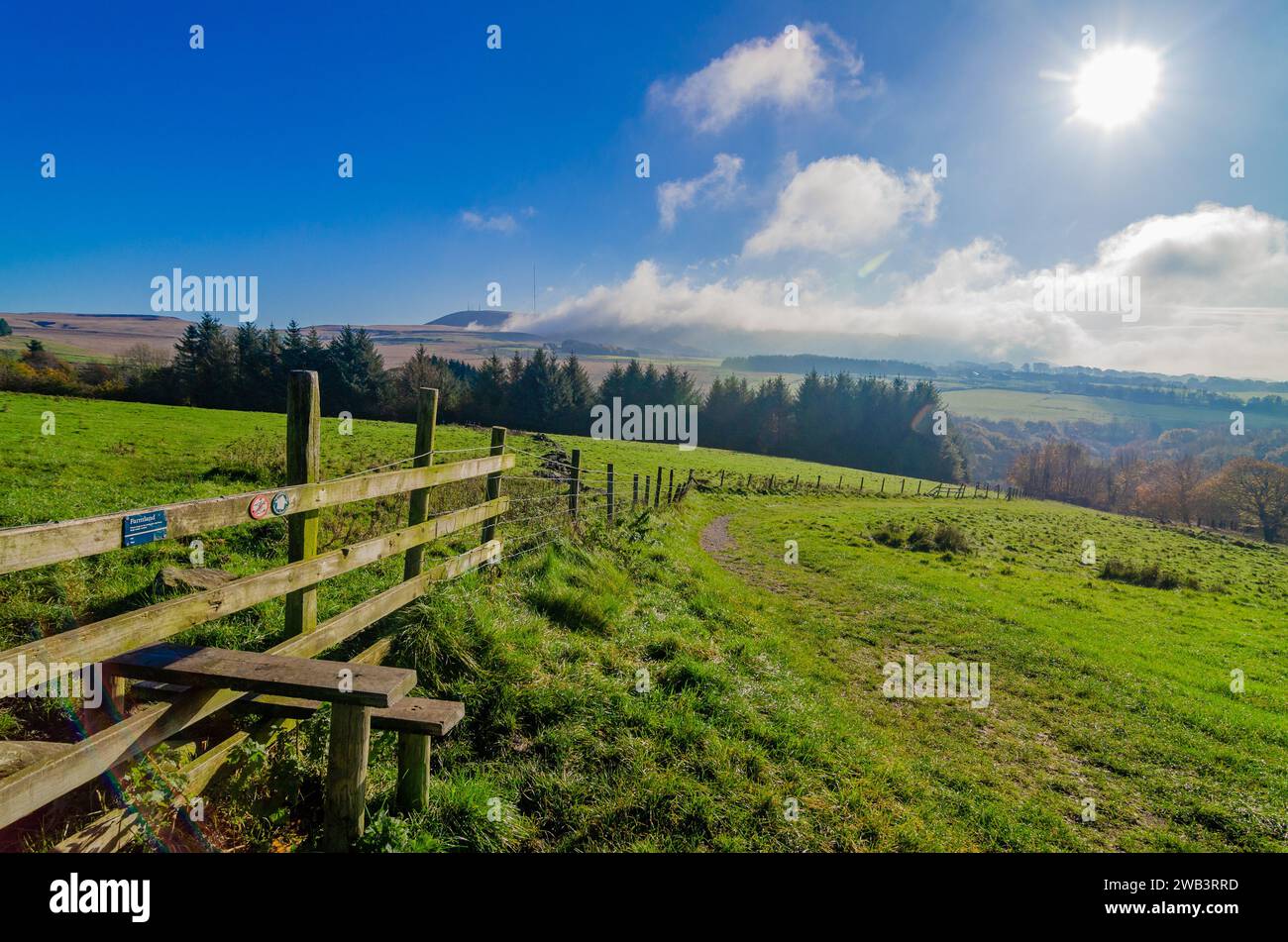 Winter Hill und Rivington Pike mit Wolken und Nebel von Ackerland mit Linsenflecken Stockfoto