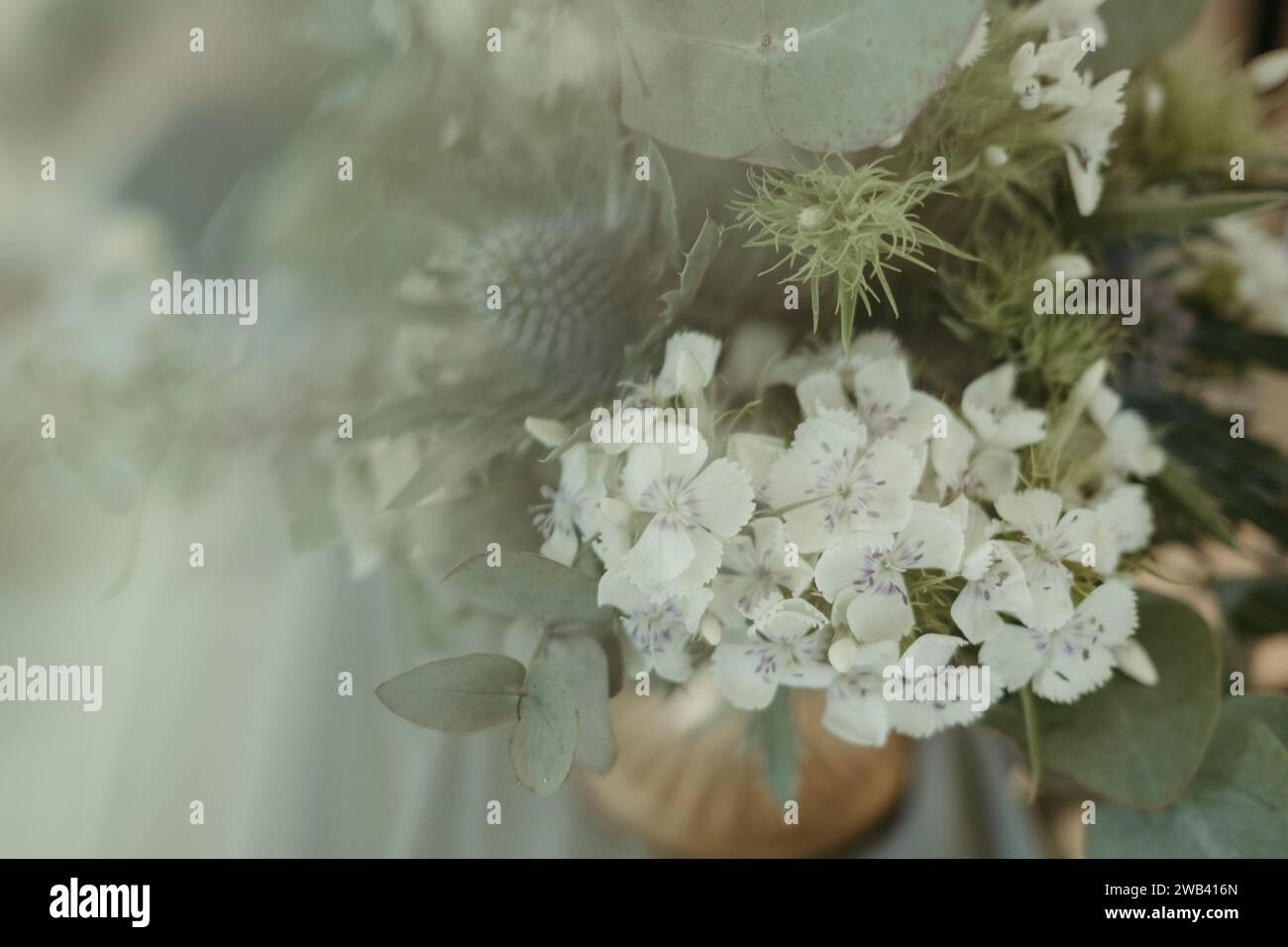 Eine Vase aus der Nähe, gefüllt mit unberührten weißen Blumen, reich verziert mit komplizierten Mustern Stockfoto