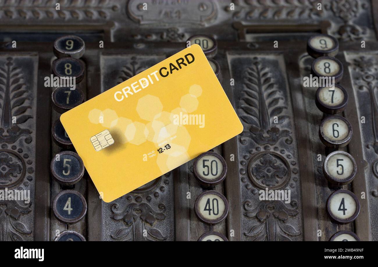 Eine Kreditkarte befindet sich in einer antiken Kasse, eine Schnittstelle zwischen modernem Banking und vergangener Zahlungskultur. Stockfoto